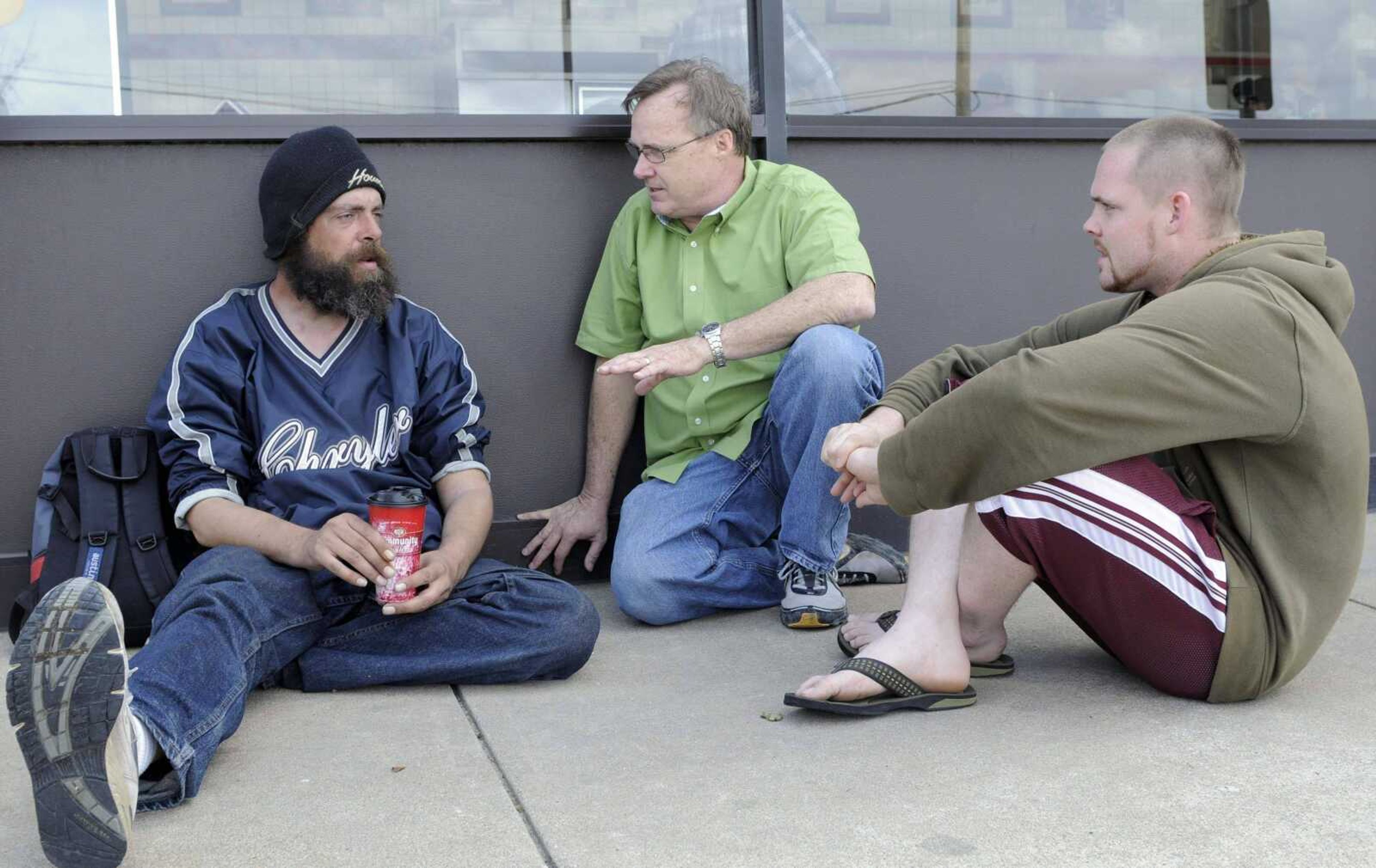 Pat Sullivan ~ Associated Press<br>Tim Edwards, left, talks with Kevin Dolan, center, and son Sean outside a Waffle House restaurant Feb. 27 in Houston.