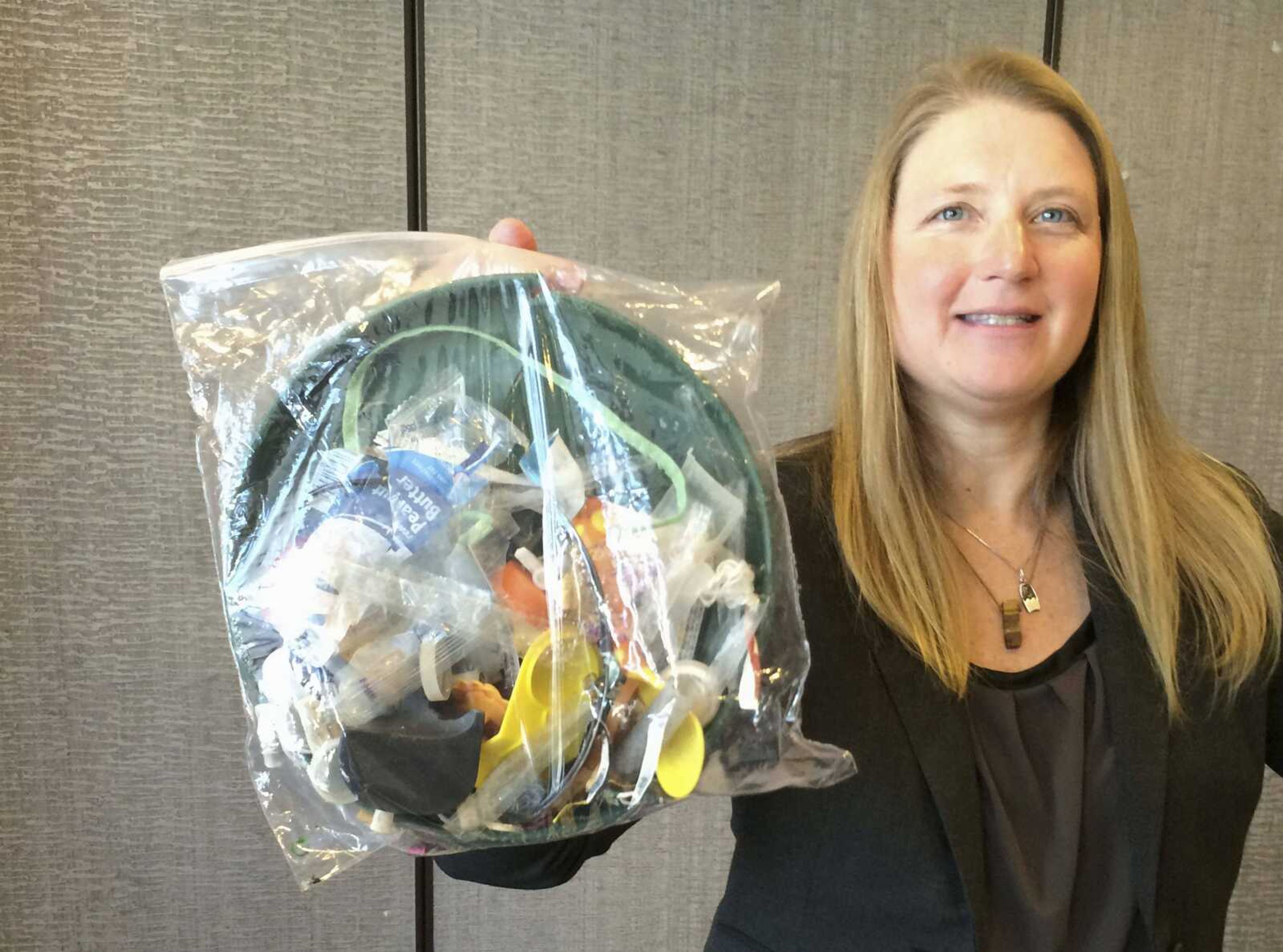 Jenna Jambeck, an environment engineering professor at the University of Georgia, holds a plastic baggie with trash collected in 2015 from a cleanup at Panama Beach, Florida.