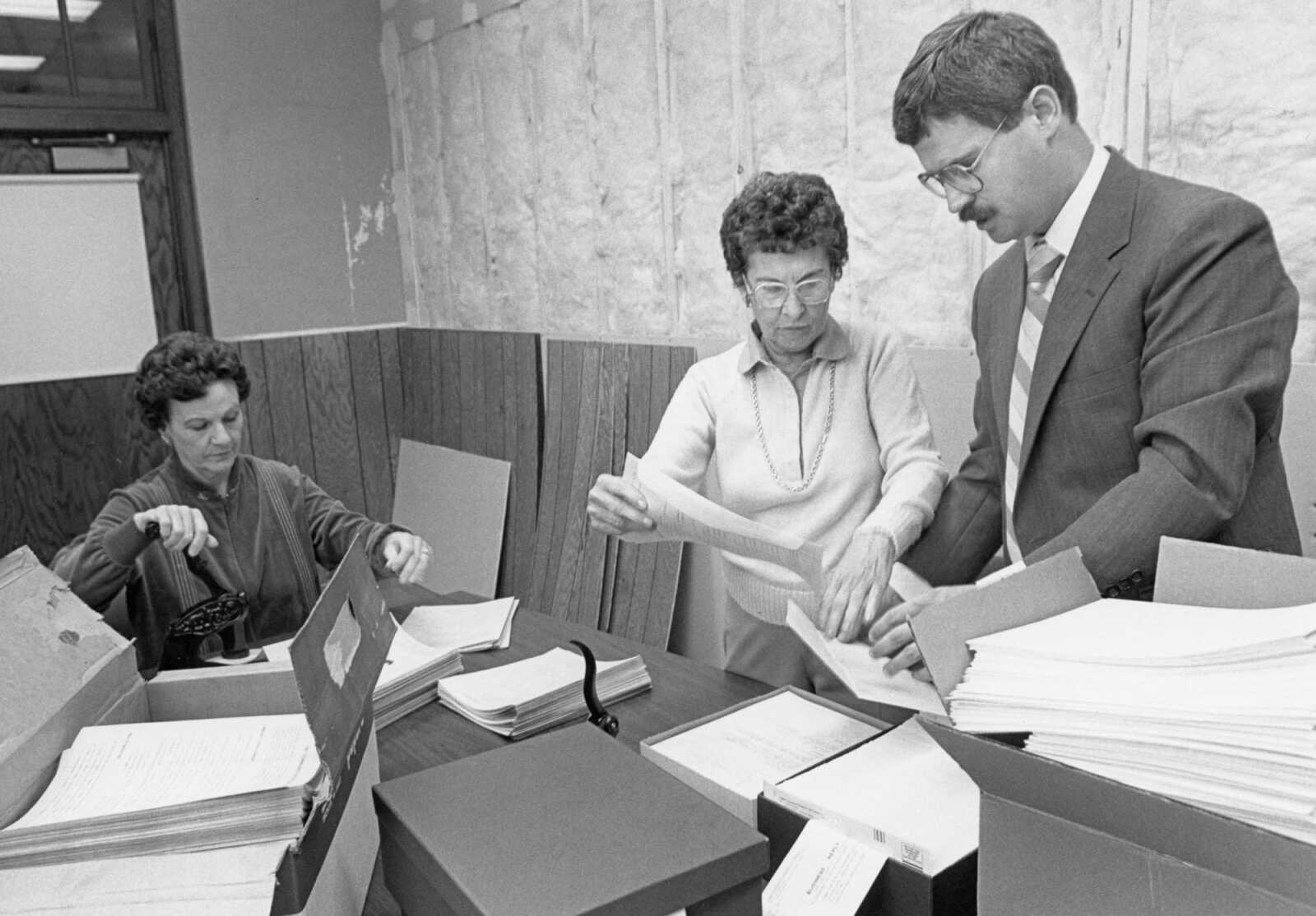 Published Oct. 21, 1987.
Volunteers Betty Campbell, left, and Cecelia "Skeets" Sonderman, center, assisted city finance director Al Stoverink, chairman of the Cape Girardeau Chamber of Commerce Community Development Committee, in preparing community attitude survey forms for mailing at City Hall. The survey forms were mailed to 1,367 Cape Girardeau voters. (Mark Sterkel ~ Southeast Missourian archive)