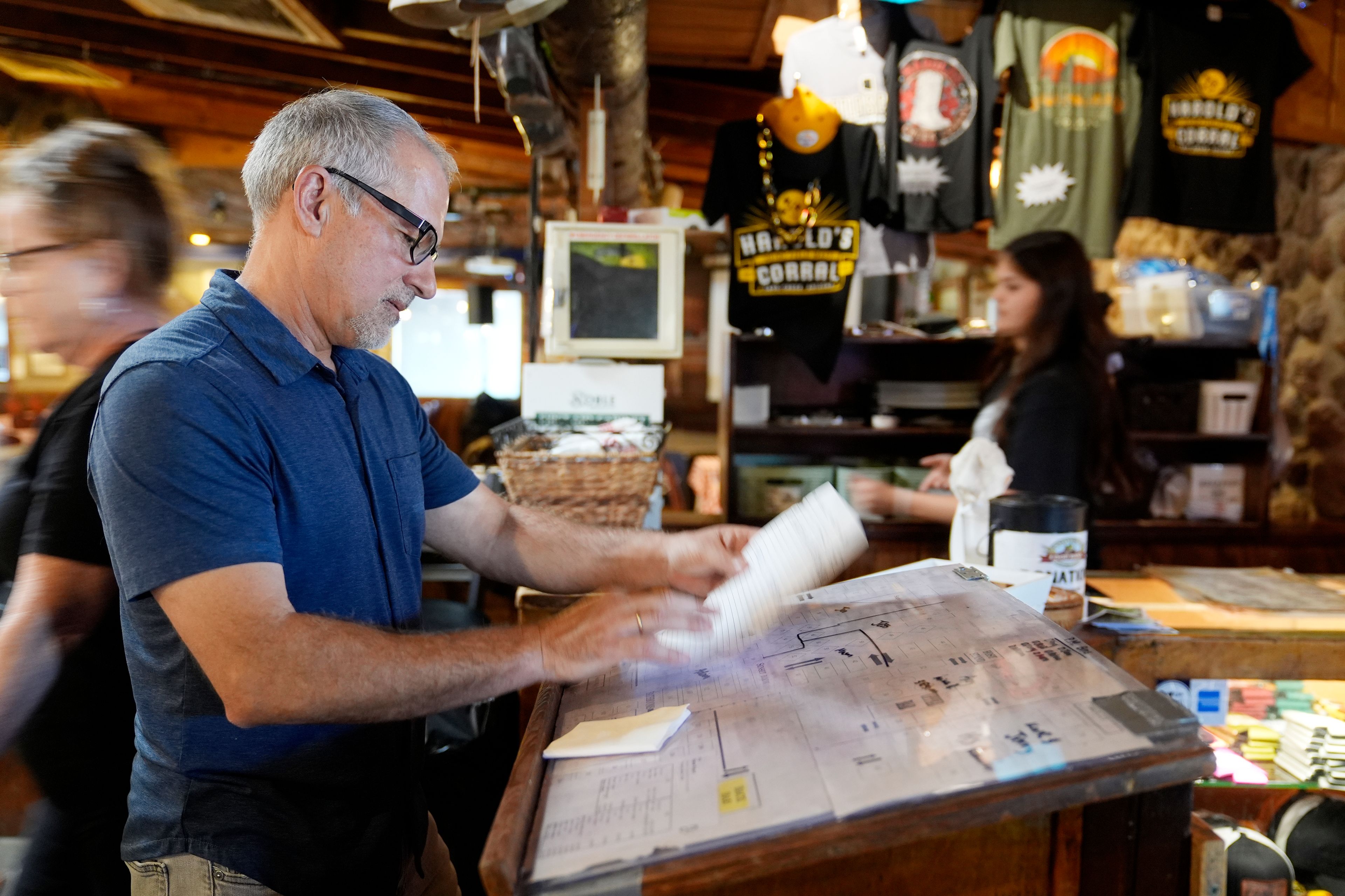 Dan Piacquadio, owner of Harold's Cave Creek Corral, checks for reservations at the entrance of the restaurant as he waits for the upcoming election regarding Arizona Prop 138 on minimum wage Thursday, Oct. 3, 2024, in Cave Creek, Ariz. (AP Photo/Ross D. Franklin)