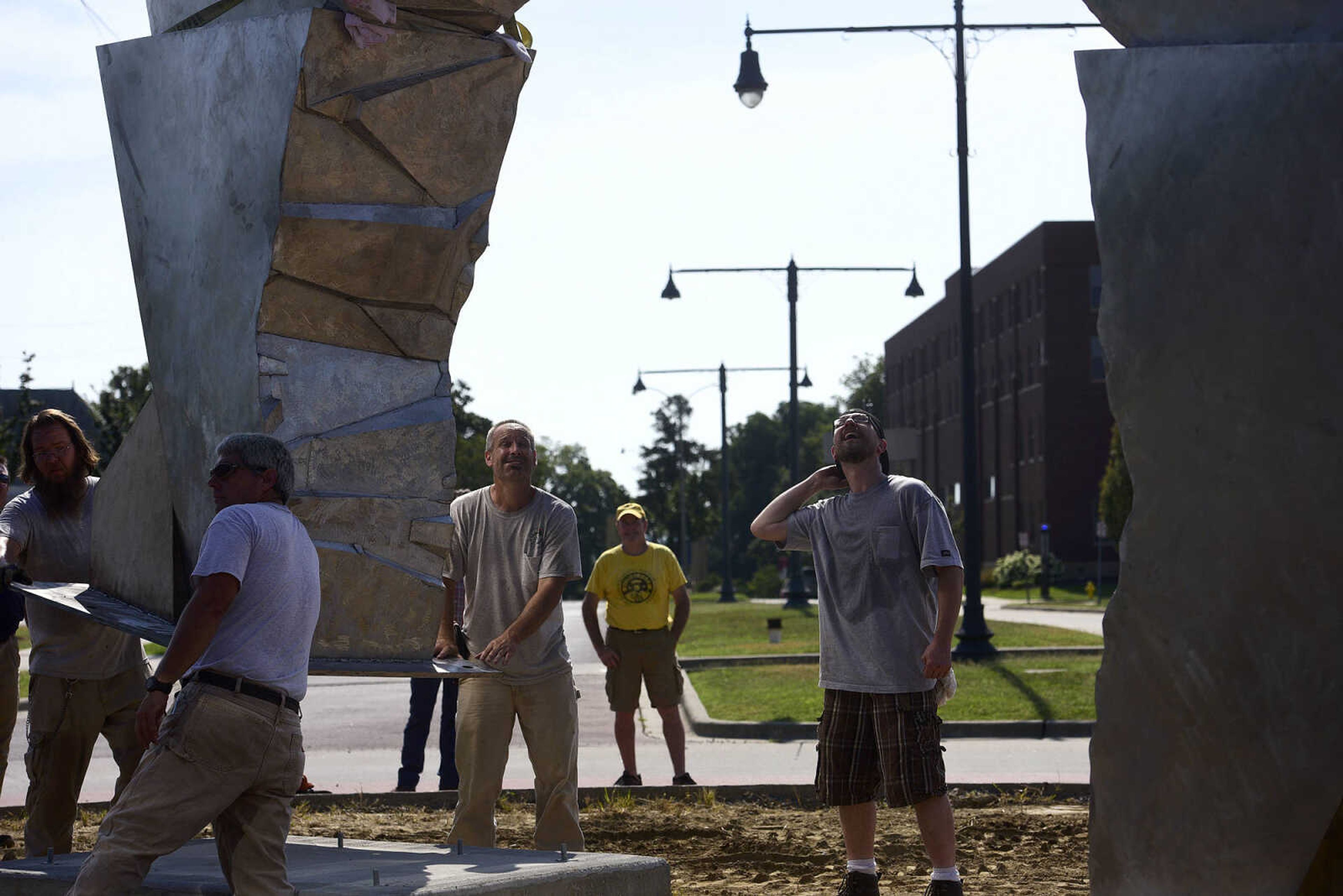 Chris Wubbena, right, oversees the installation of his 14-foot sculpture as Cape Girardeau Parks and Recreation guide the second piece to its platform in the Fountain Street roundabout on Monday, July 24, 2017, near the River Campus in Cape Girardeau.