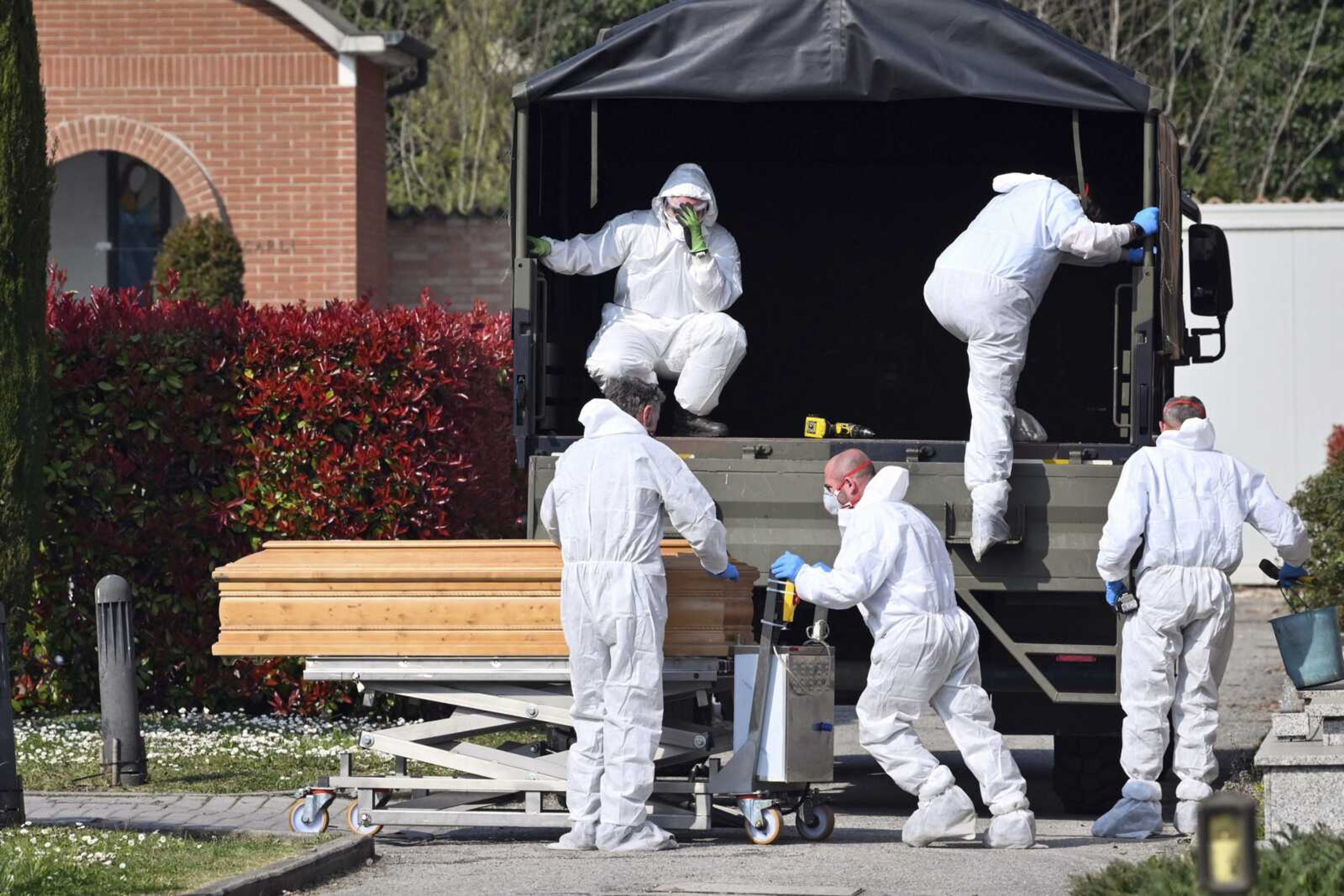 Coffins are downloaded at the Ferrara cemetery, northern Italy, from a military convoy coming from Bergamo, a city at the epicenter of the coronavirus outbreak in northern Italy.