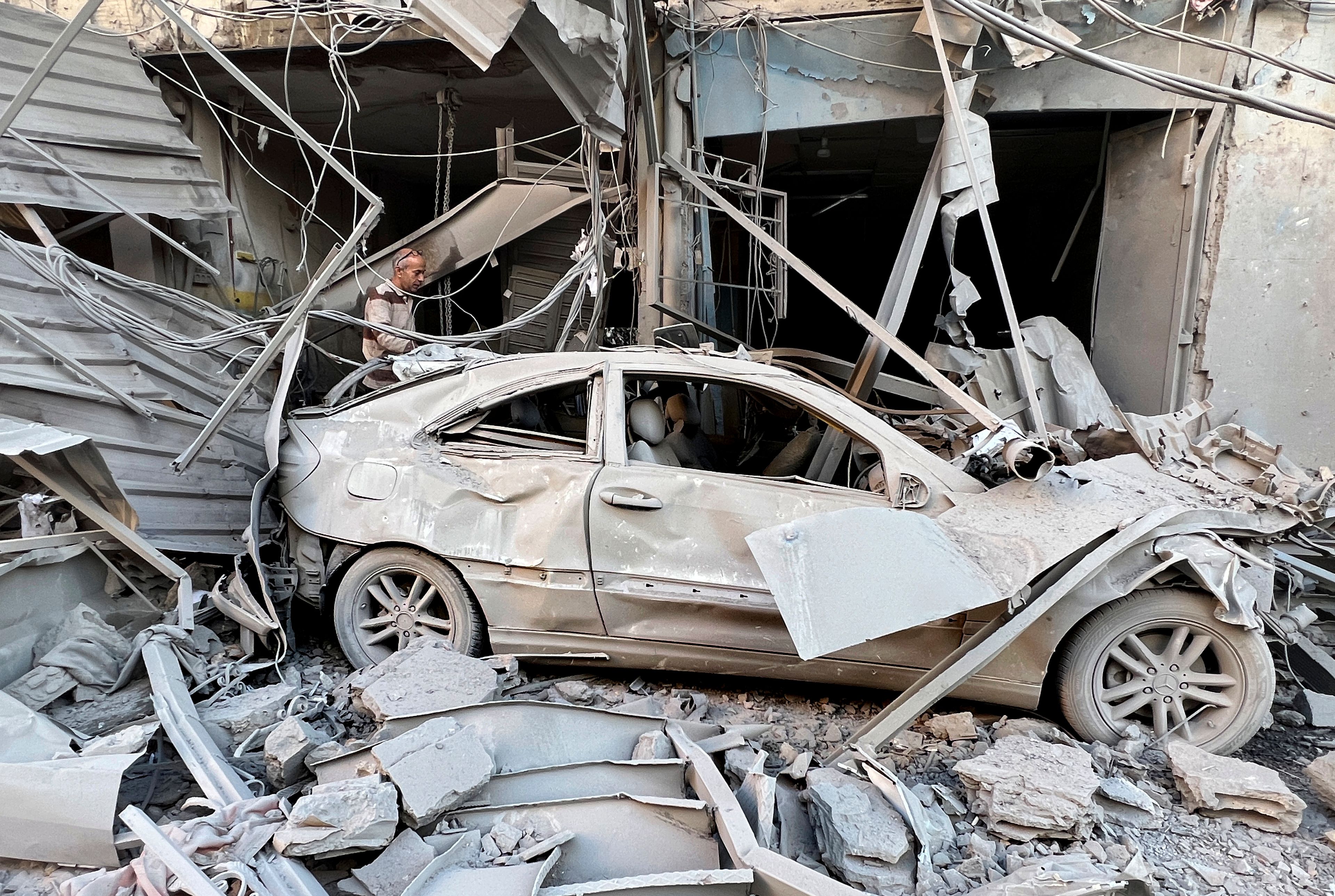 A man checks his destroyed shop at a street that was hit in an Israeli airstrike in Dahiyeh, in the southern suburb of Beirut, Lebanon, Thursday, Nov. 14, 2024. (AP Photo/Hussein Malla)