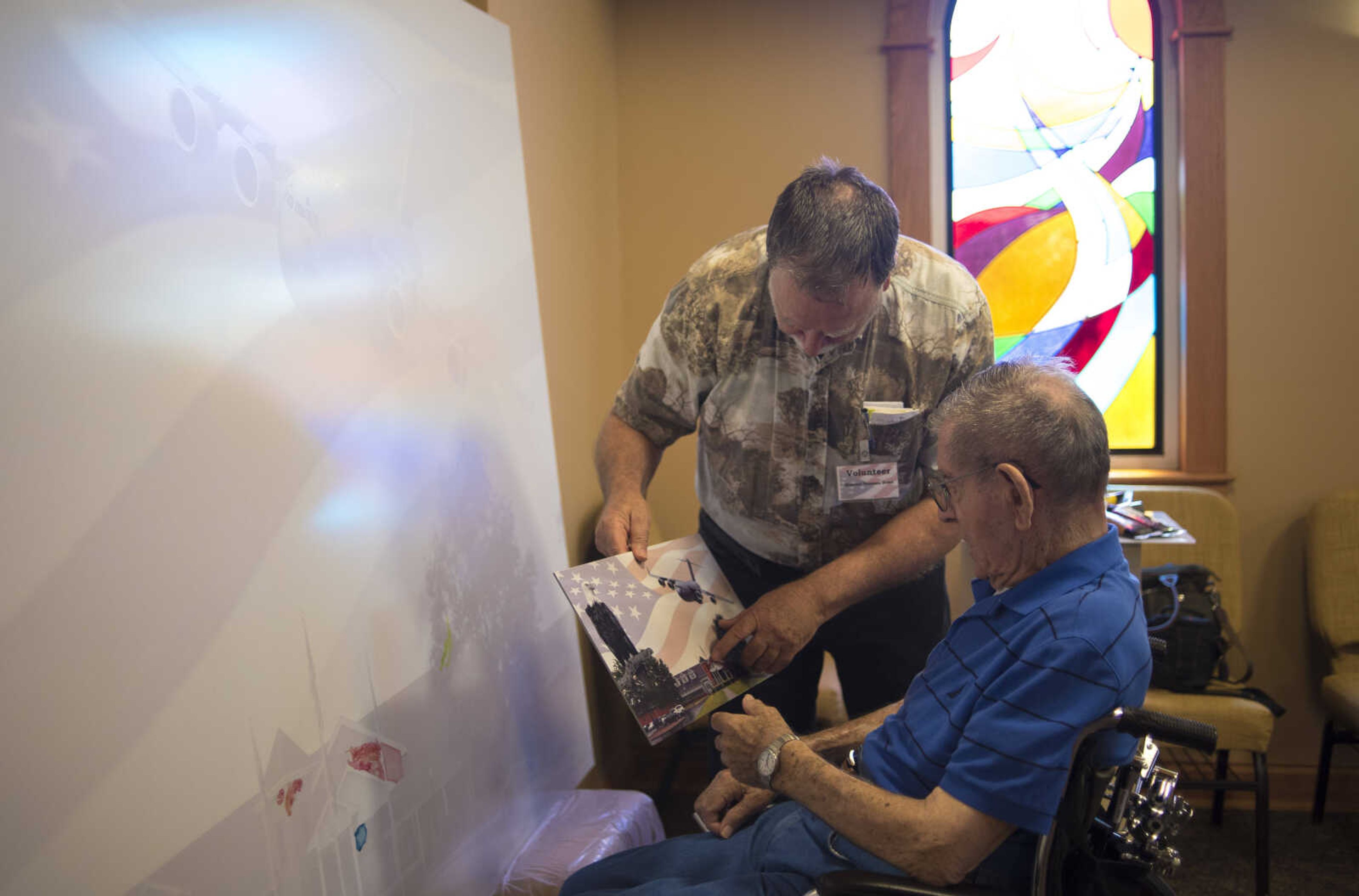 Aaron Horrell holds up a smaller picture of what the canvas will look like for T.J. Miller for Paint-For-A-Cause where the residents of the Missouri Veterans Home will be given the opportunity to paint first on the big image Friday, July 28, 2017 in Cape Girardeau. Aaron Horrell will then take the painting to the SEMO District Fair where people can also help paint to raise money for the home.