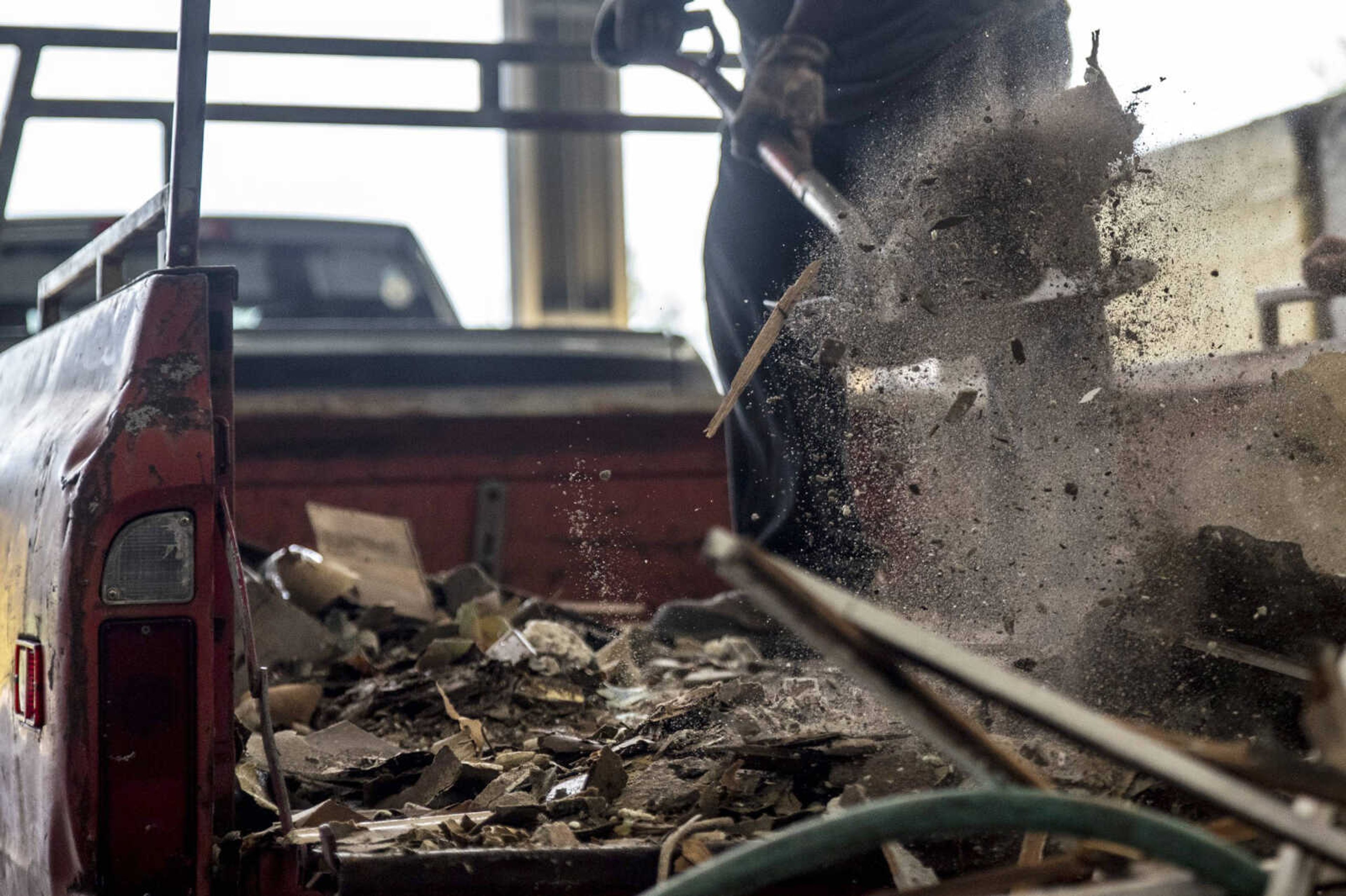 Sebastian Todd Thomas shovels gutted house materials to be discarded out of a truck bed Monday at the Cape Girardeau Public Works Transfer Station in Cape Girardeau.