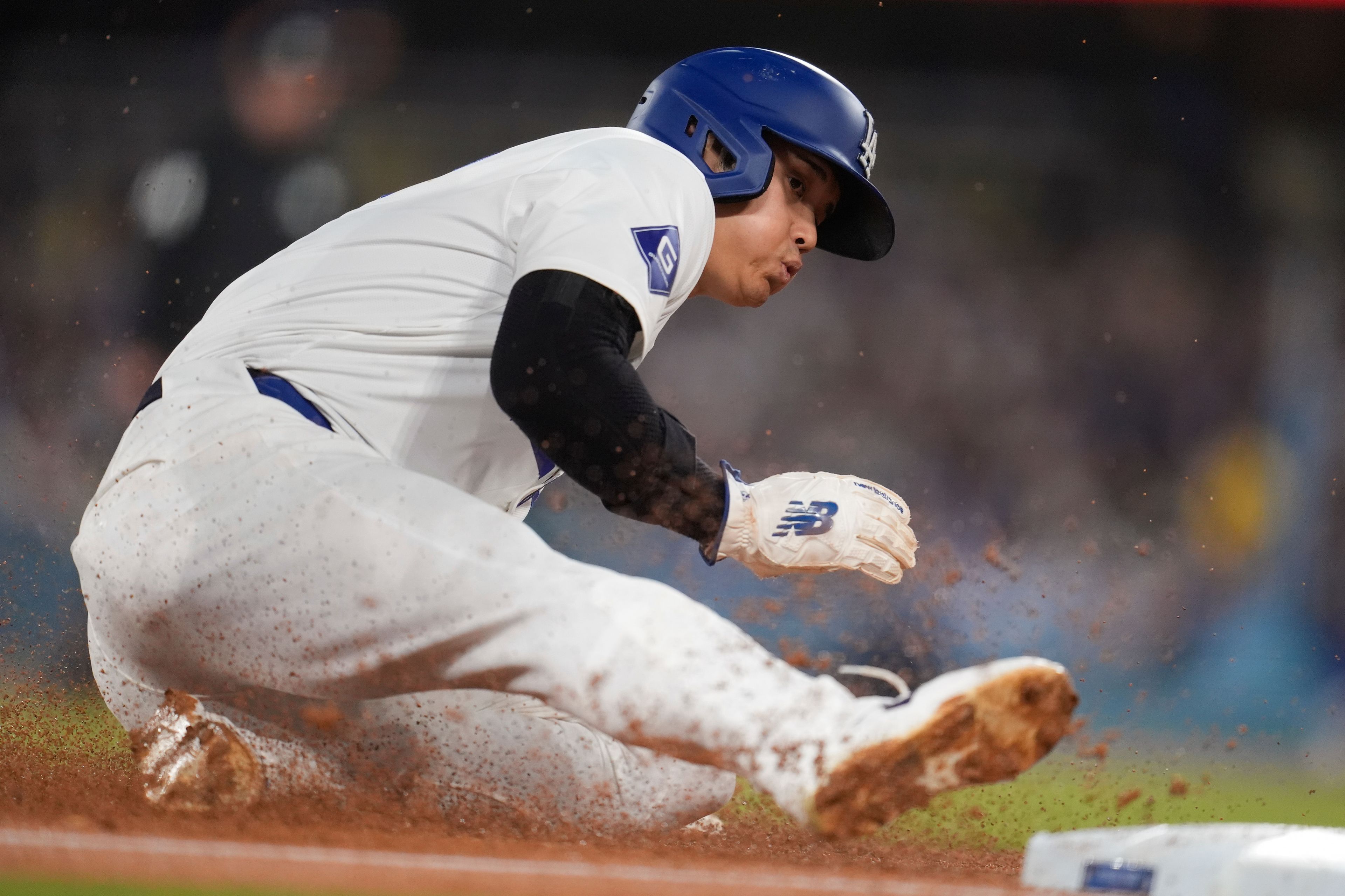 Los Angeles Dodgers' Shohei Ohtani steals third base during the fourth inning of a baseball game against the Arizona Diamondbacks, Tuesday, May 21, 2024, in Los Angeles. (AP Photo/Marcio Jose Sanchez)