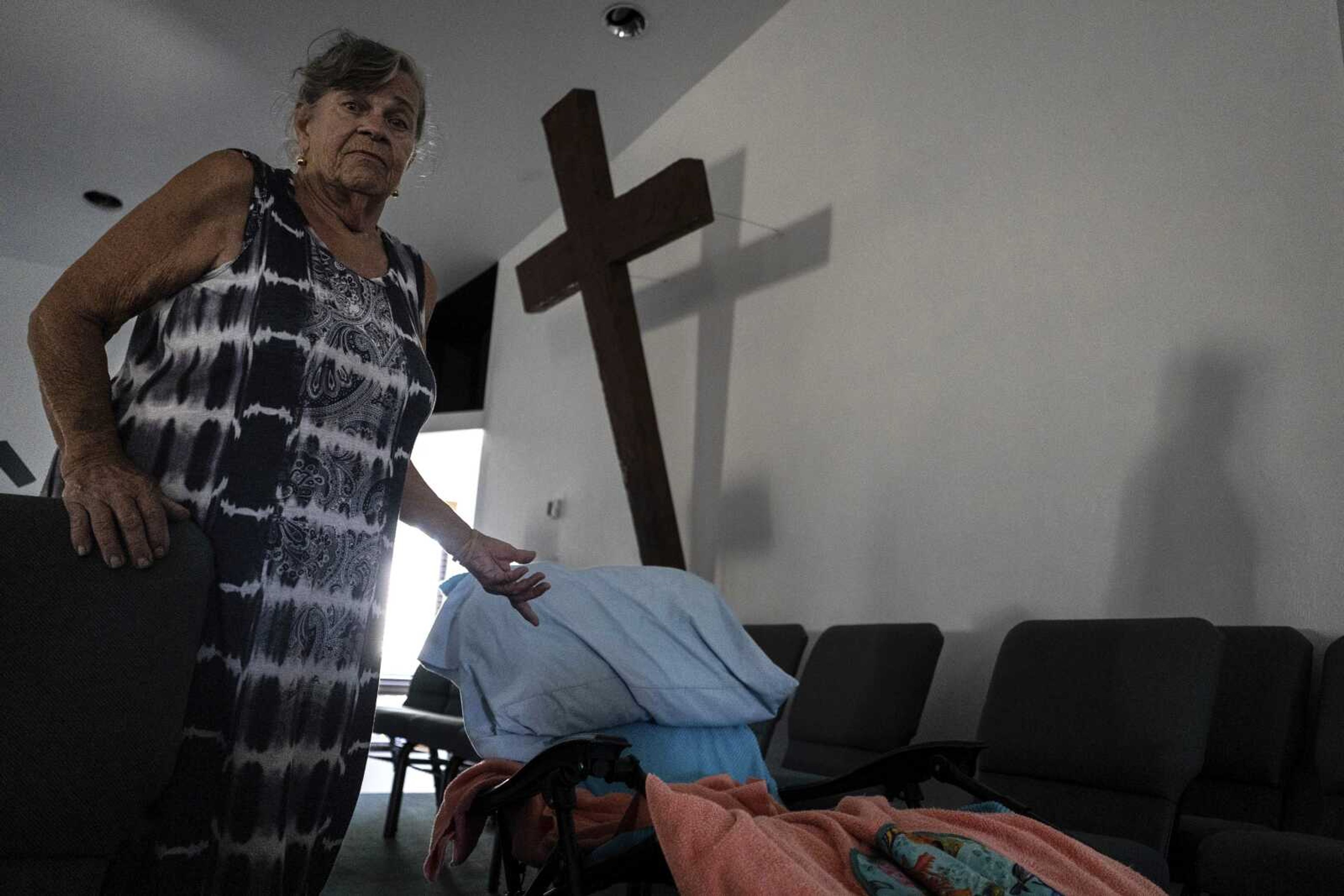 Barbara Wasko stands beside her makeshift bed on the pulpit of the Southwest Baptist Church on Sunday in Fort Myers, Florida. Wasko is living at the church after her home was destroyed by Hurricane Ian.