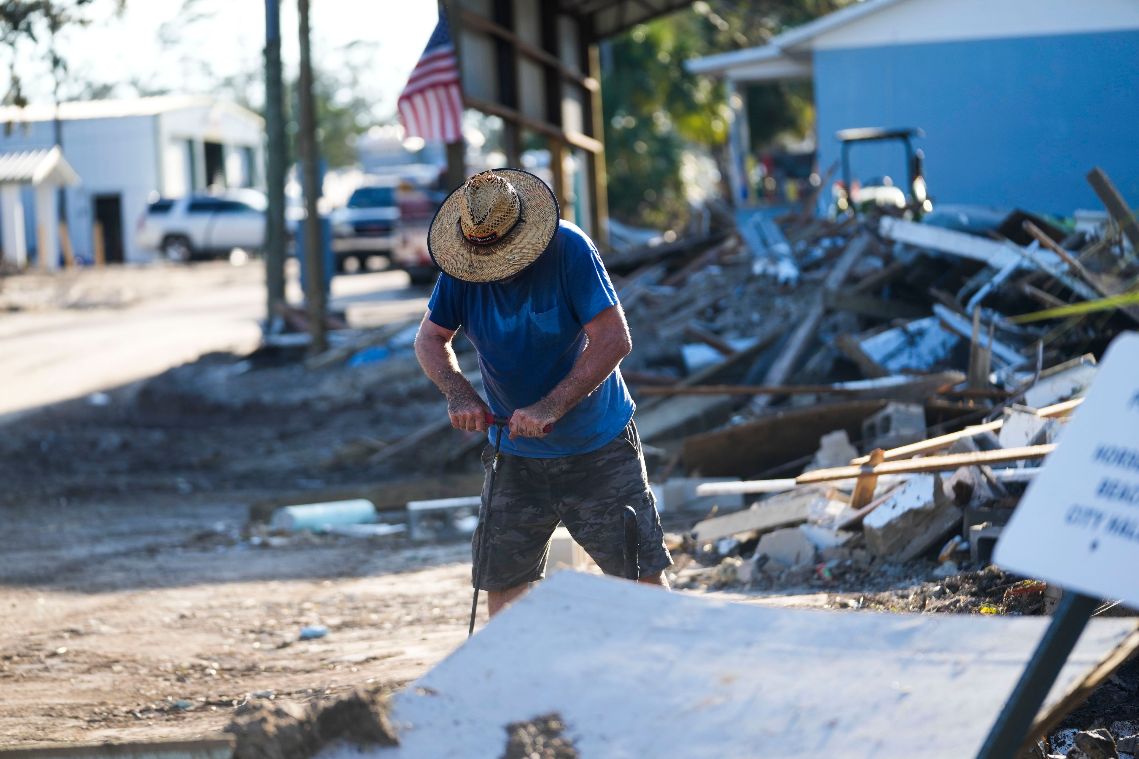 Chris Jordan, maintenance manager for Horseshoe Beach, tries to find a water shutoff valve amid the rubble of the destroyed city hall in the aftermath of Hurricane Helene, in Horseshoe Beach, Fla., Sunday, Sept. 29, 2024. (AP Photo/Gerald Herbert)