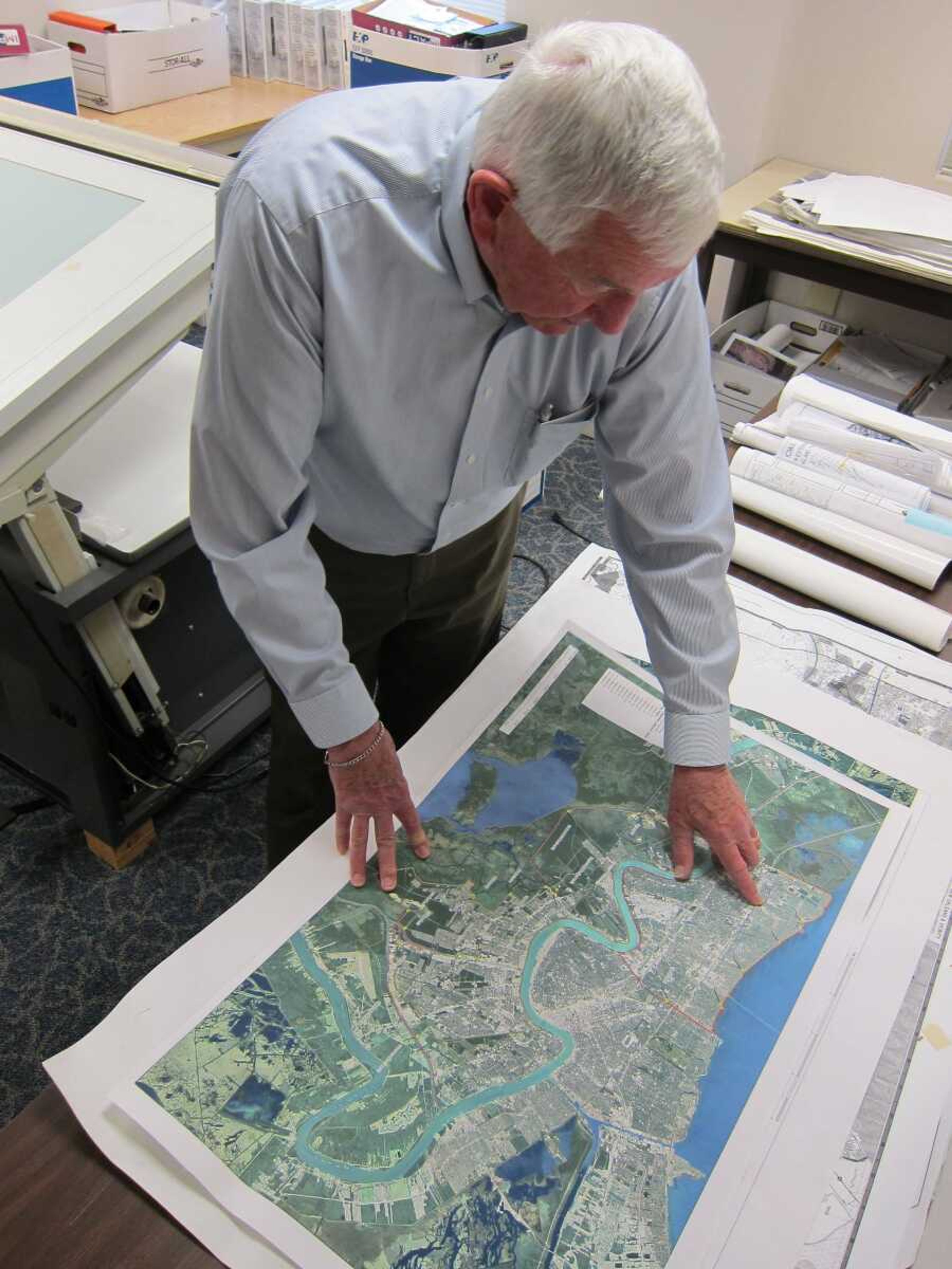 This photo taken May 3, 2013 shows John Sayles, 79, a planner at Stanley Consultants, reviewing a map from a New Orleans project he worked on, at the company&#237;s headquarters in Muscatine, Iowa. Sayles is among the employees at Stanley who have participated in &#236;phased retirement,&#238; in which a worker can cut back their hours in the months or years before their formal retirement, and continue to work part-time after. Employers around the country offer phased retirement, giving older workers a chance to transition more slowly to their post-career life. (AP Photo/Matt Sedensky)