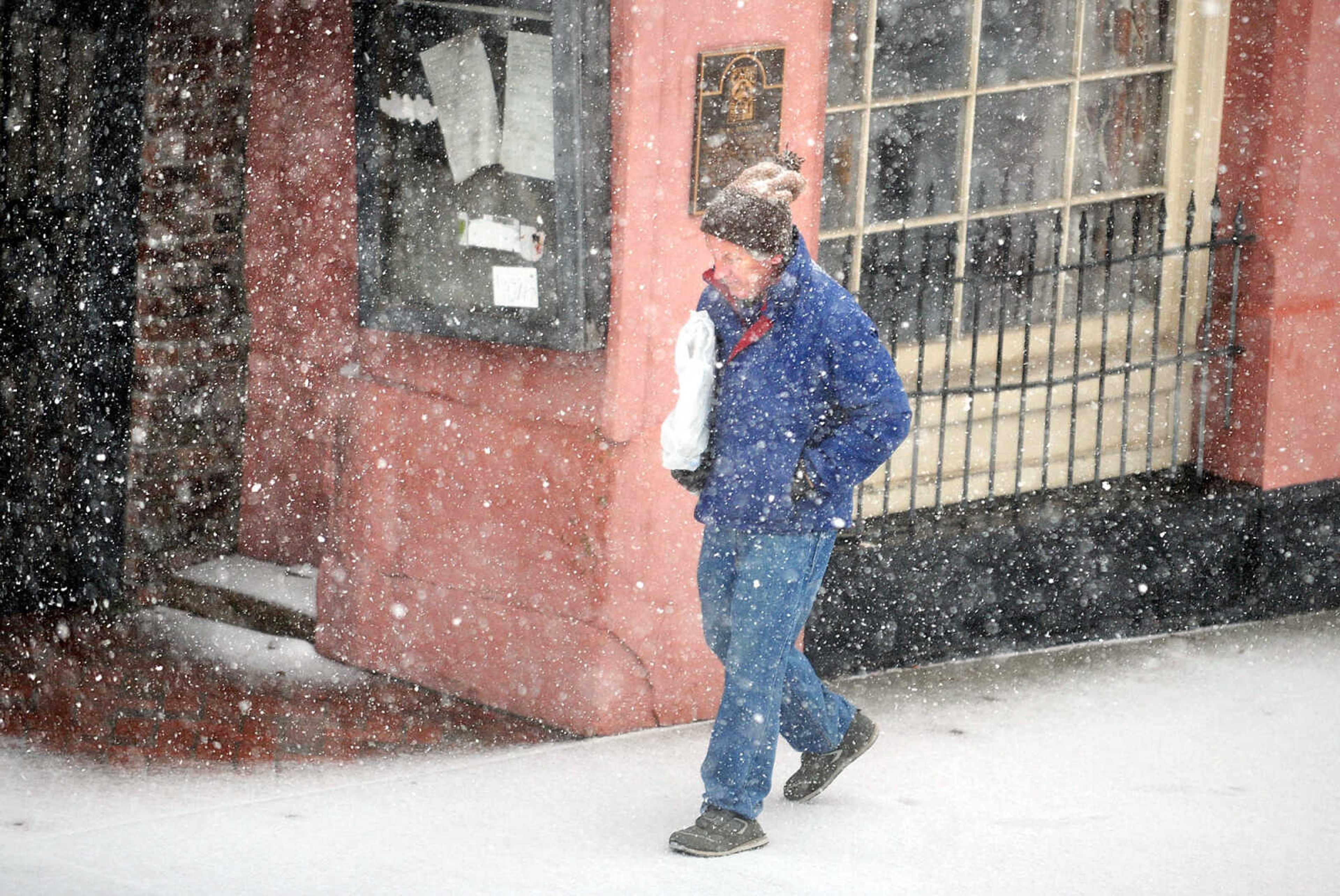 LAURA SIMON ~ lsimon@semissourian.com

A man walks along Broadway through the falling snow, Tuesday afternoon, Feb. 4, 2014.