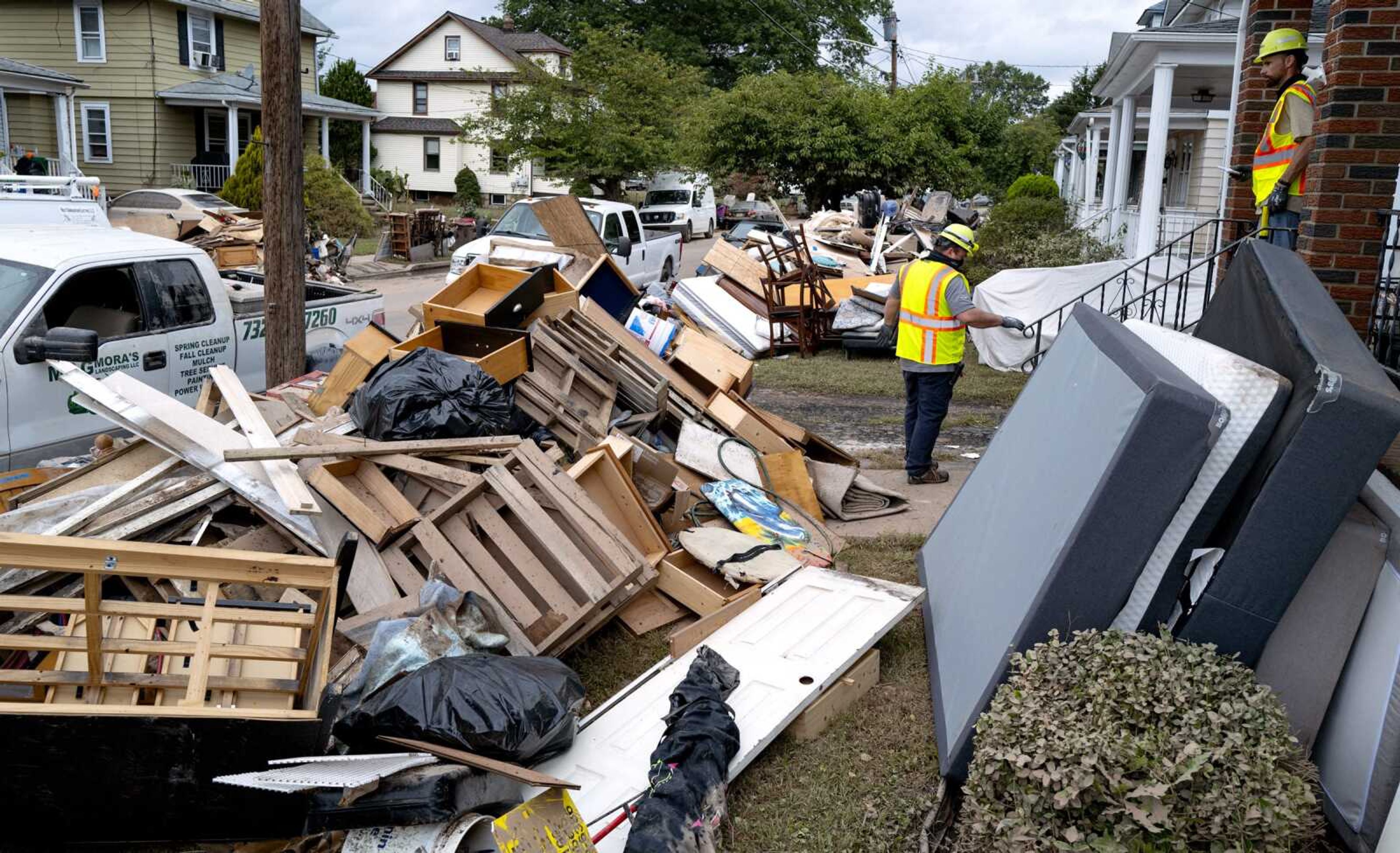 Utility workers work Sunday among debris from flood damage caused by the remnants of Hurricane Ida in Manville, New Jersey. Flood-stricken families and business owners across the Northeast are hauling waterlogged belongings to the curb and scraping away noxious mud as cleanup from Ida moves into high gear.