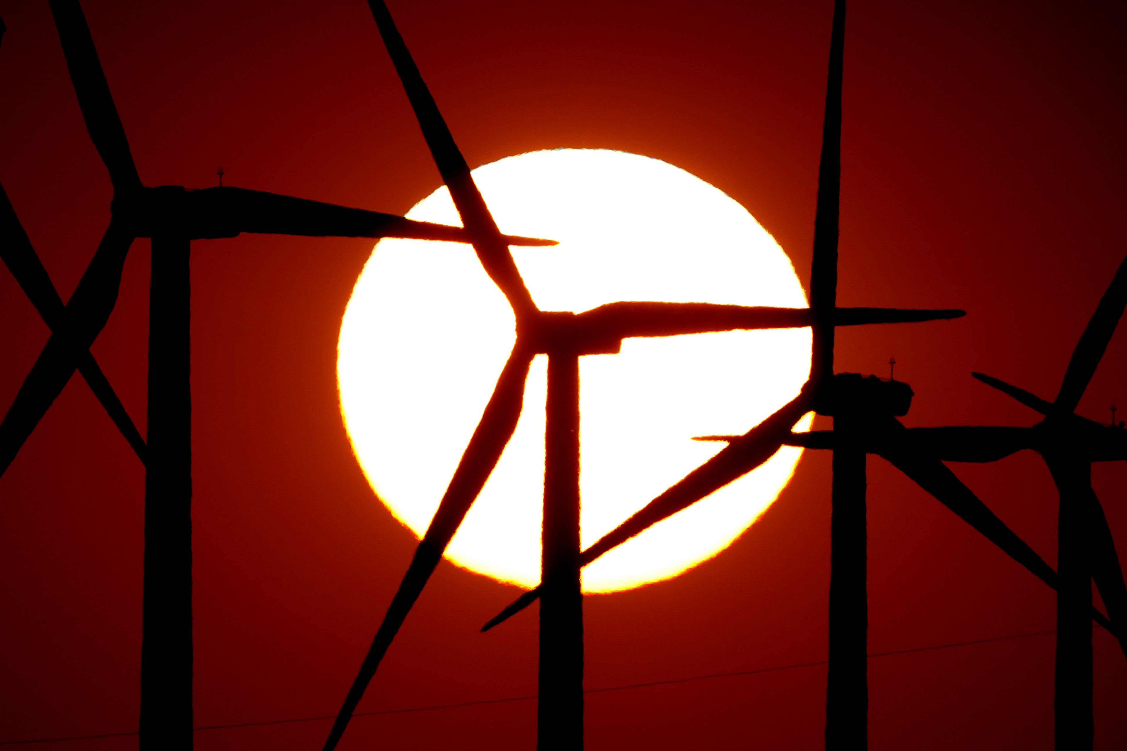 Wind turbines are silhouetted against the setting sun at the Spearville Wind Farm, Sunday, Sept. 29, 2024, near Spearville, Kan. (AP Photo/Charlie Riedel)