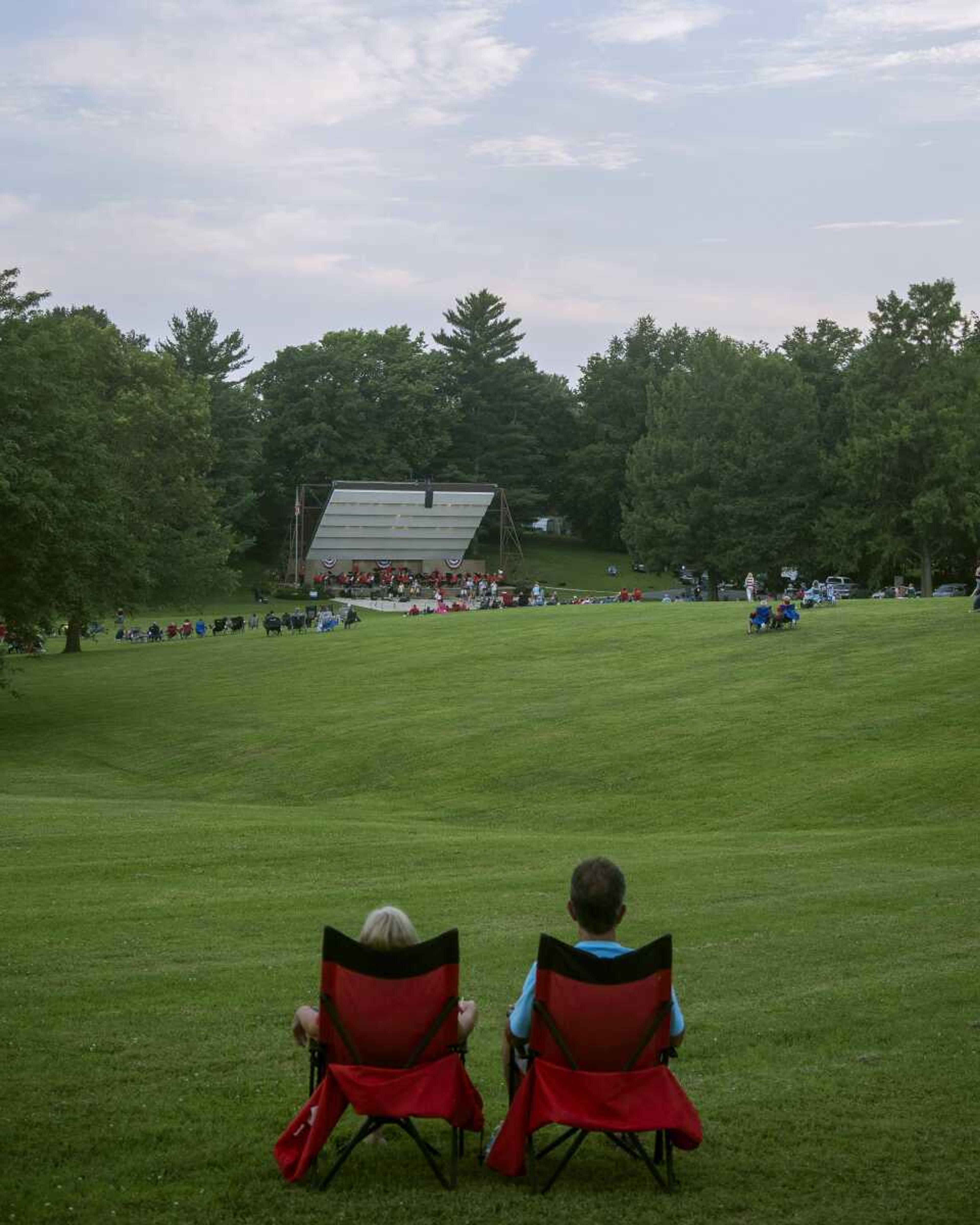 A couple enjoys a musical performance from a distance on the lawn of the Jackson Municipal Band Shell during an Independence Day celebration.