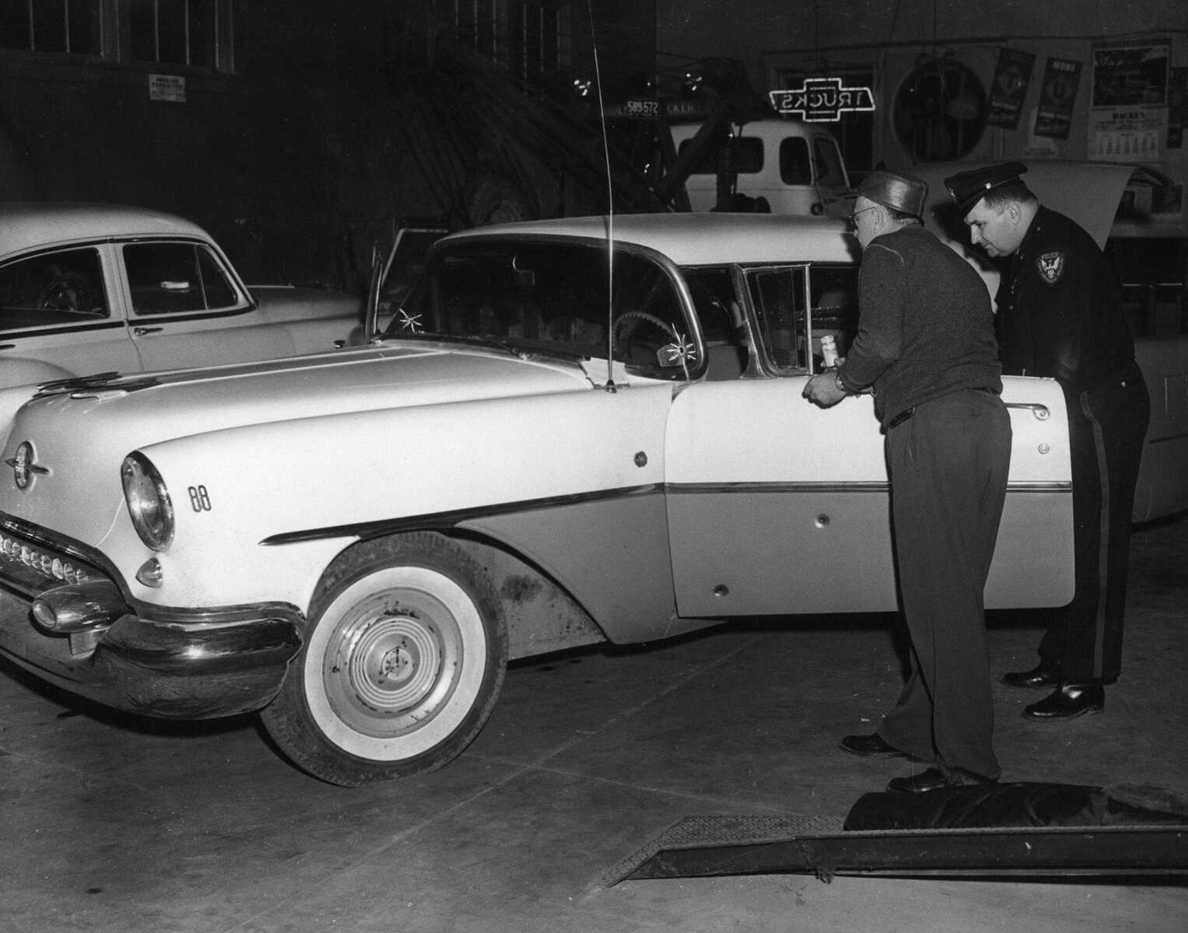 Two bullet holes in the windshield, noted in the above picture by small cracks, were caused by police bullets as the officers battled two fugitives on Highway 61 Friday night. (Don Kremer Studio) (Published Saturday, March 11, 1961, pg. 4B)