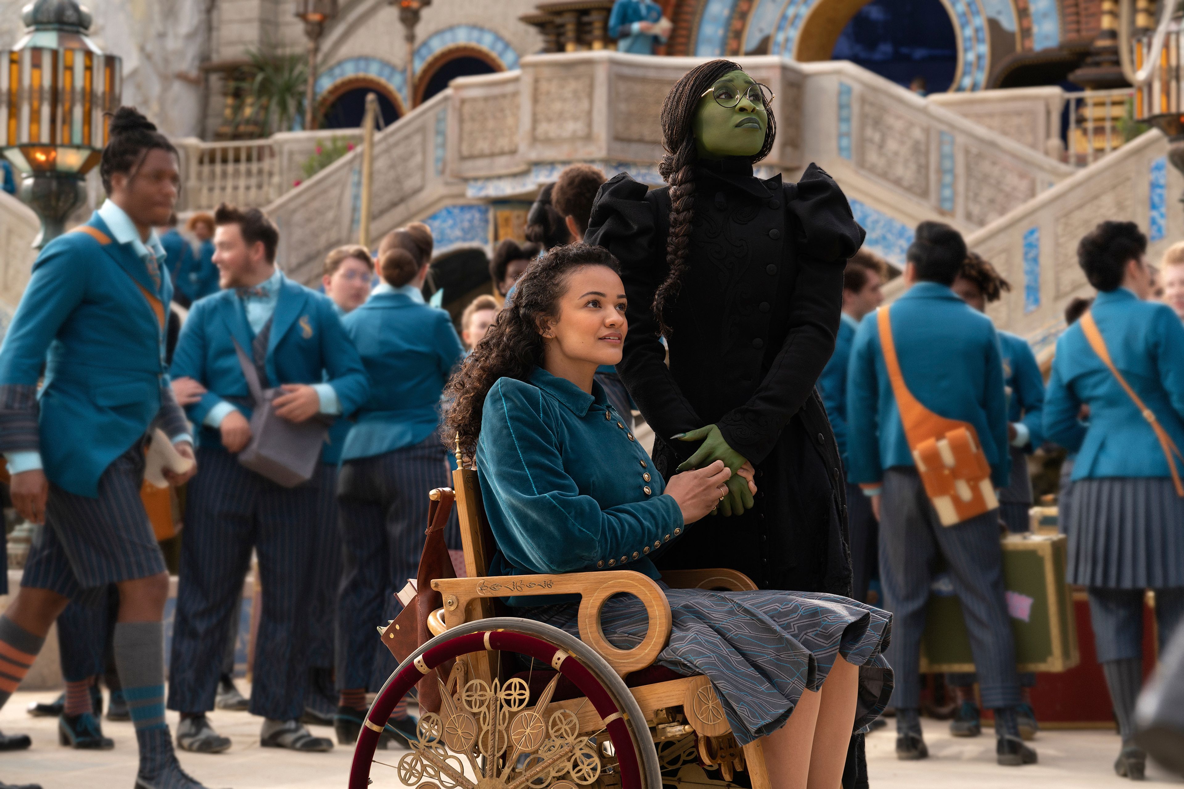 his image released by Universal Pictures shows Marissa Bode, seated center, and Cynthia Erivo in a scene from the film "Wicked." (Universal Pictures via AP)