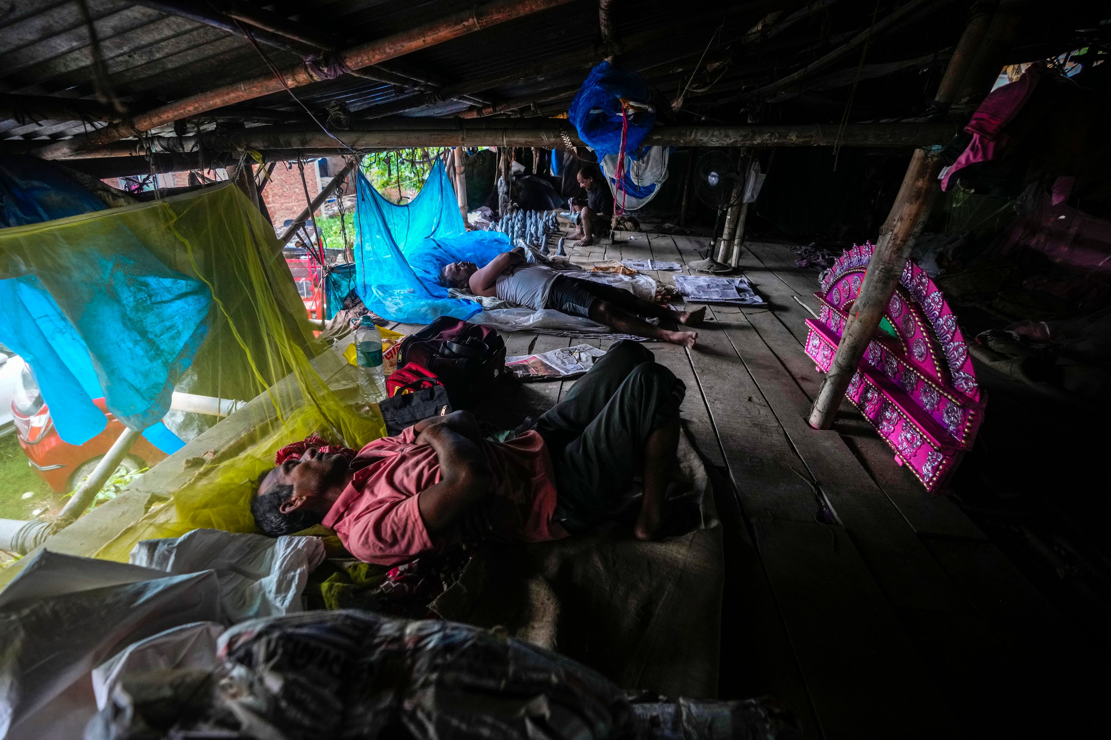 Artisans take rest on the floor of a workshop where they make mud idols of the Hindu goddess Durga and other deitiesduring the Durga Puja festival in Guwahati, India, Saturday, Oct. 5, 2024. (AP Photo/Anupam Nath)