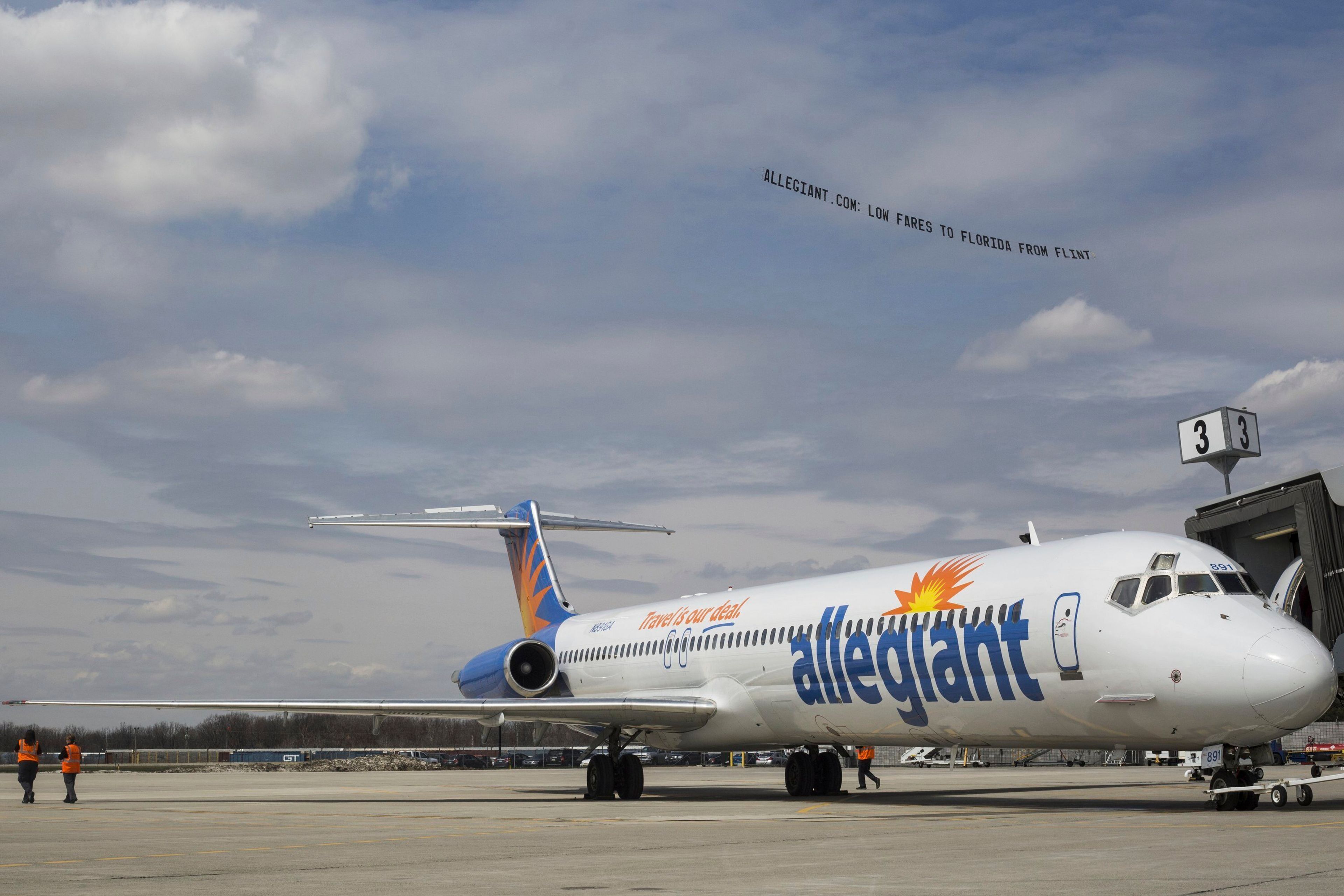 FILE - A small plane tows a banner over Flint Bishop Airport as part of ceremonies marking Allegiant Air joining Flint Bishop International Airport on April 13, 2016. (Conor Ralph/The Flint Journal- MLive.com via AP, File)