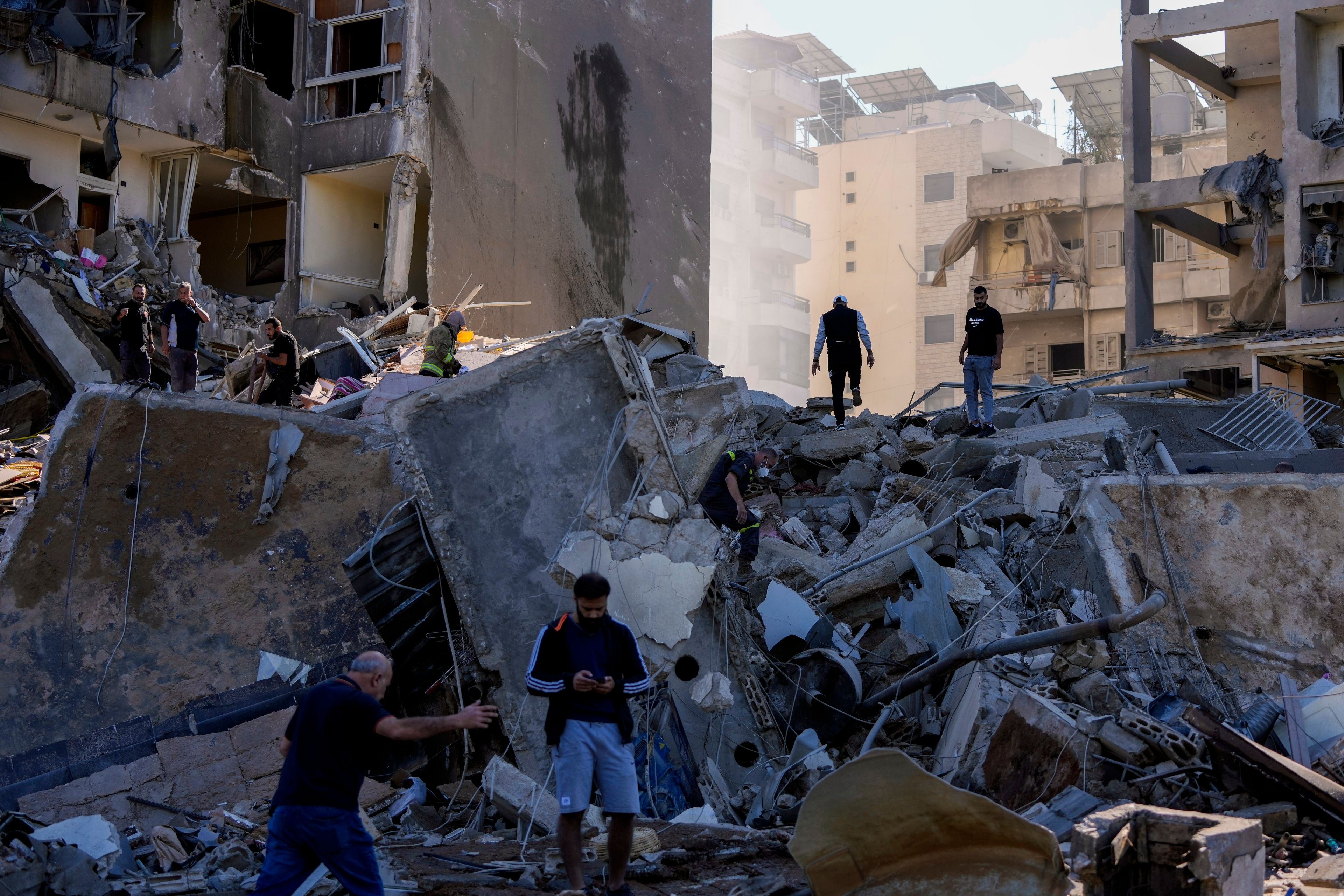 Residents check the site of an Israeli airstrike in Tayouneh, Beirut, Lebanon, Friday, Nov. 15, 2024. (AP Photo/Hassan Ammar)