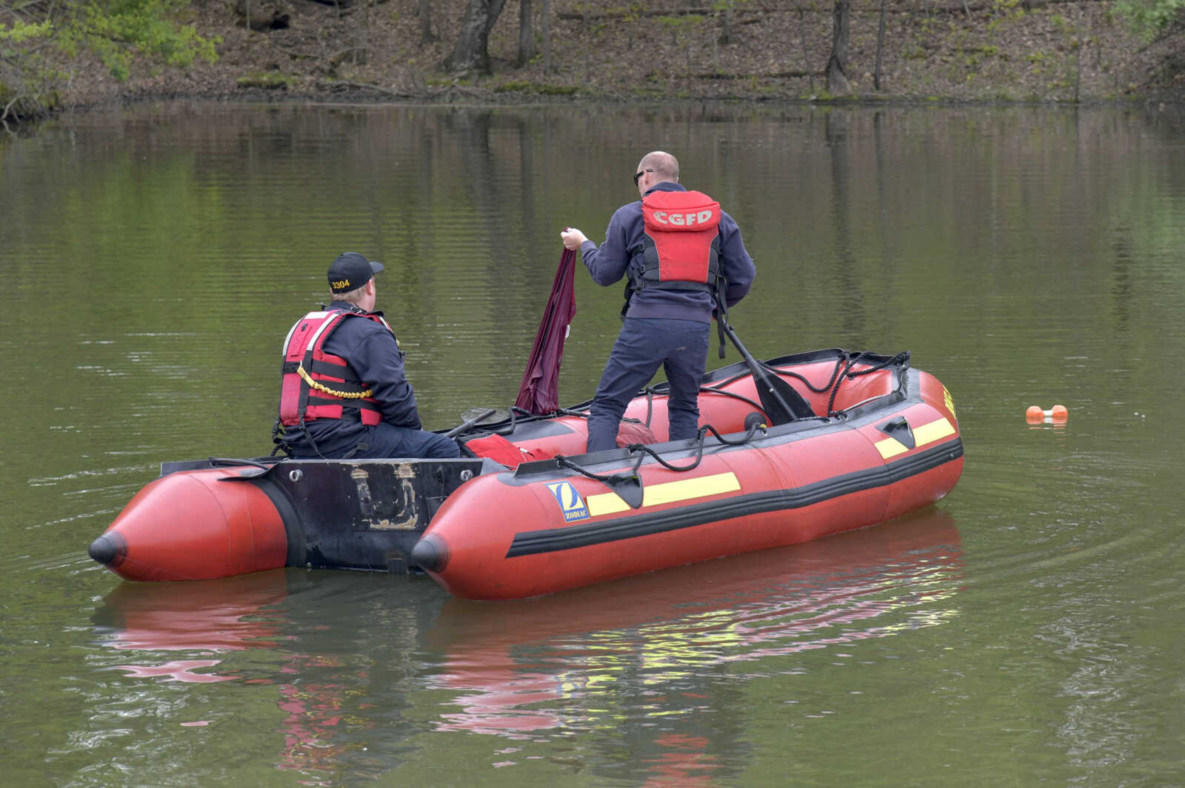 Cape Girardeau Firefighters pull what seems to be a jacket out of a pond at the Little Ponderosa Lake after rescuing the driver and before towing the car that was completely submerged on Friday, April 16, 2021.