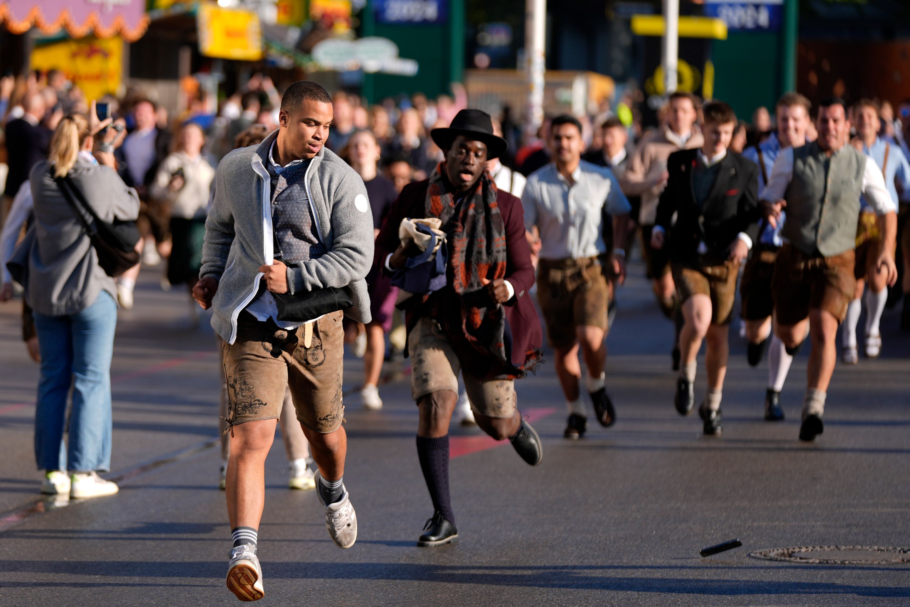 People run to enter the 189th 'Oktoberfest' beer festival in Munich, Germany, Saturday, Sept. 21, 2024. (AP Photo/Matthias Schrader)