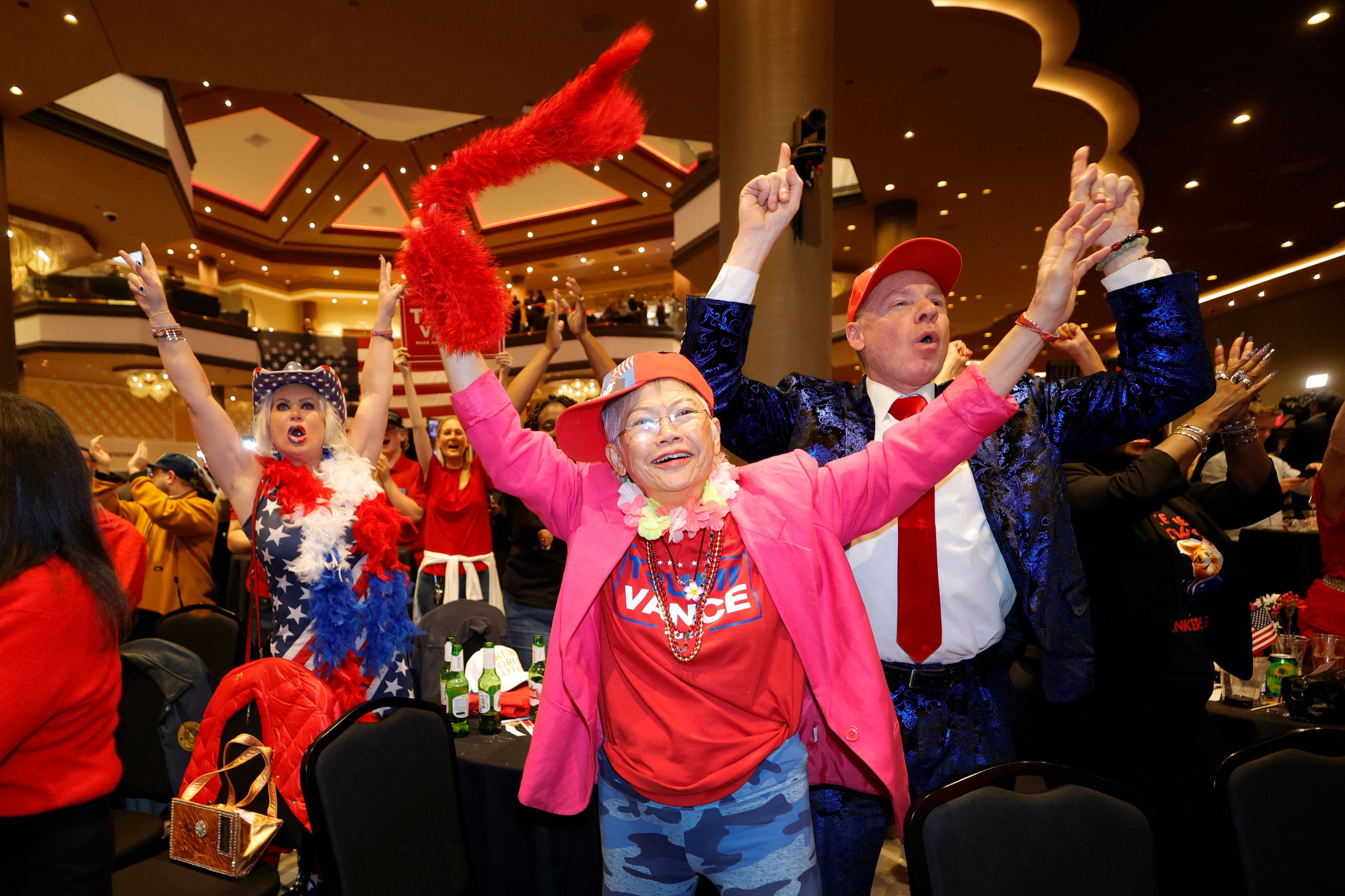 Supporters of Republican presidential nominee former President Donald Trump, Stephanie Smith, left, Sandi Steinbeck, center, and Thomas Brewer, right, cheer during a GOP election watch party at the Ahern Hotel, Tuesday, Nov. 5, 2024, in Las Vegas. (Steve Marcus/Las Vegas Sun via AP)