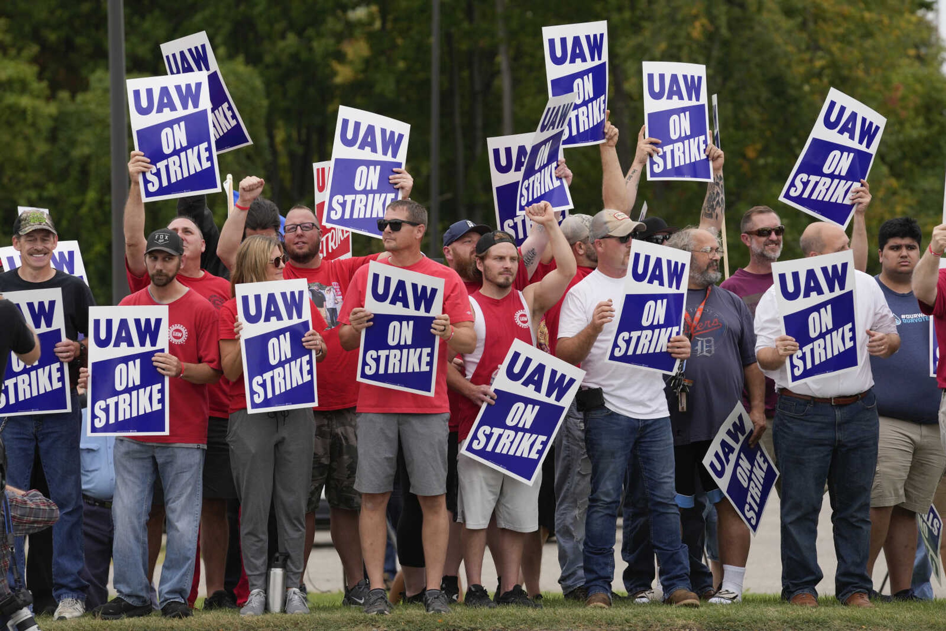 FILE - United Auto Workers members hold picket signs near a General Motors assembly plant in Delta Township, Mich., Sept. 29, 2023. About 46,000 United Auto Workers at GM are expected to wrap up voting on a tentative contract agreement in a close race that will decide the fate of the deal that ended a six-week strike.  The union is expected to announce GM results Thursday evening. (AP Photo/Paul Sancya, File)