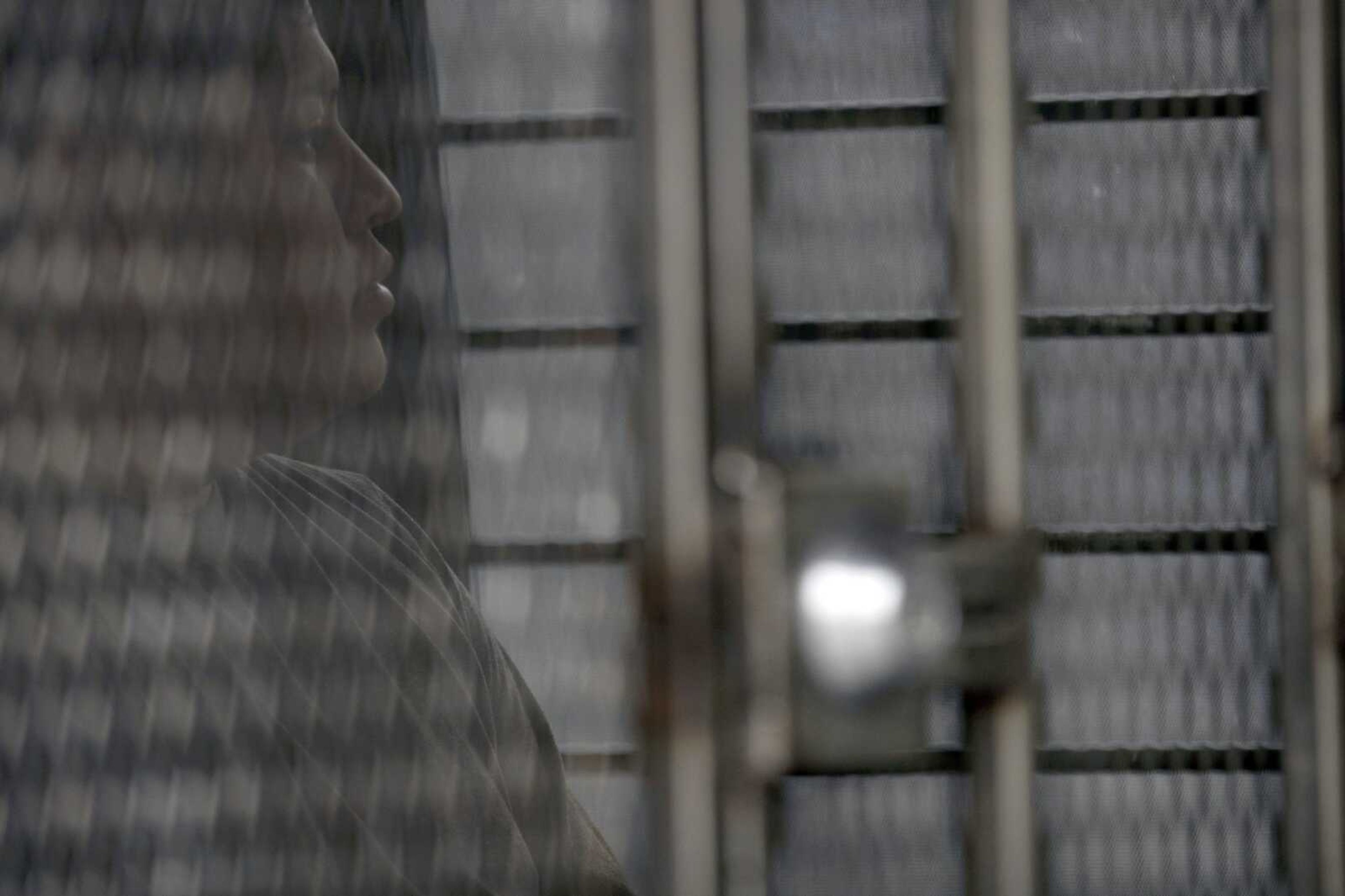 A man in hand and ankle cuffs waits in a van after being detained during a U.S. Immigration and Customs Enforcement (ICE) operation July 8 in Escondido, California. The administration of President Donald Trump announced Monday it will vastly expand the authority of immigration officers to deport migrants without allowing them to first appear before judges.