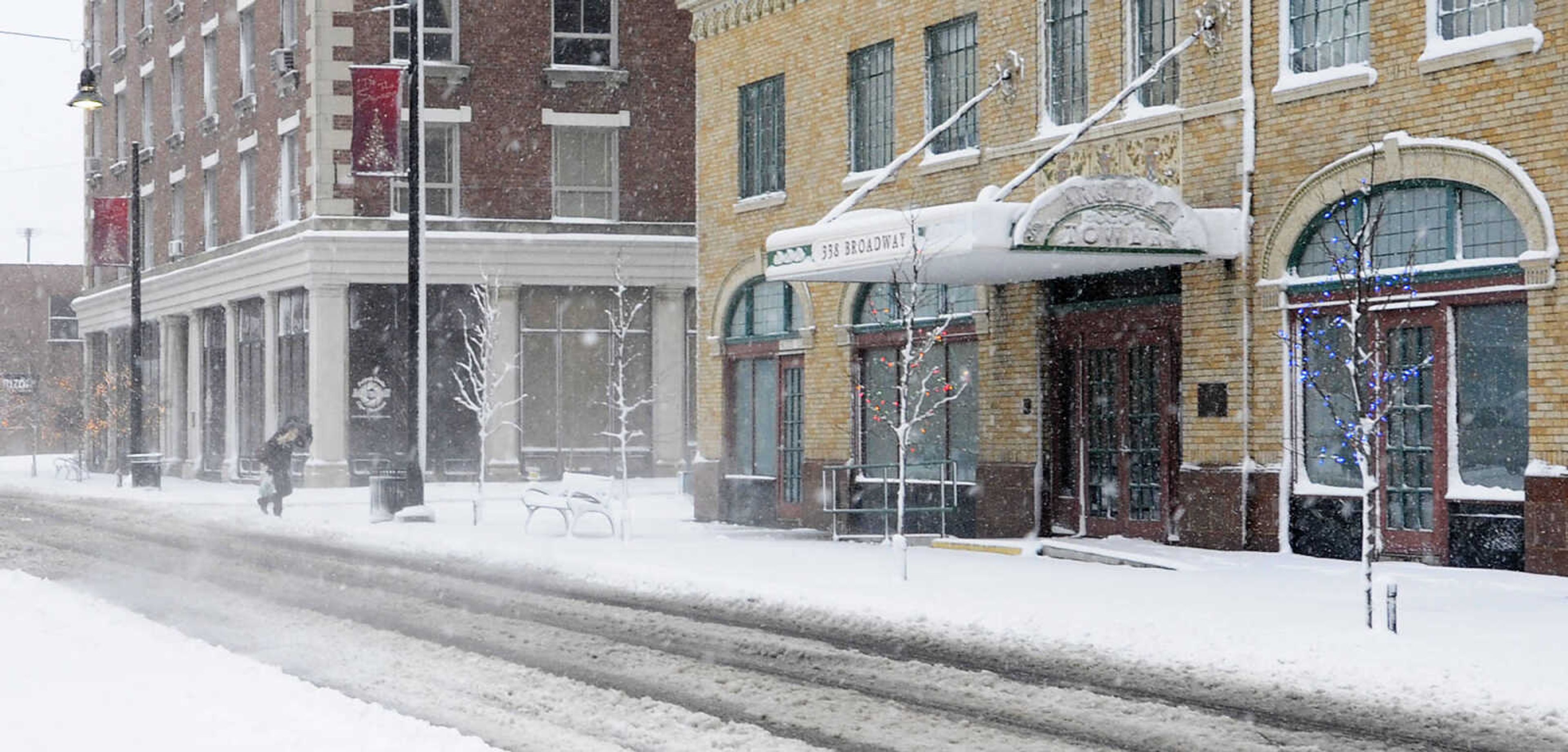 A pedestrian tries to block blowing snow along Broadway Wednesday morning in downtown Cape Girardeau. (Adam Vogler)