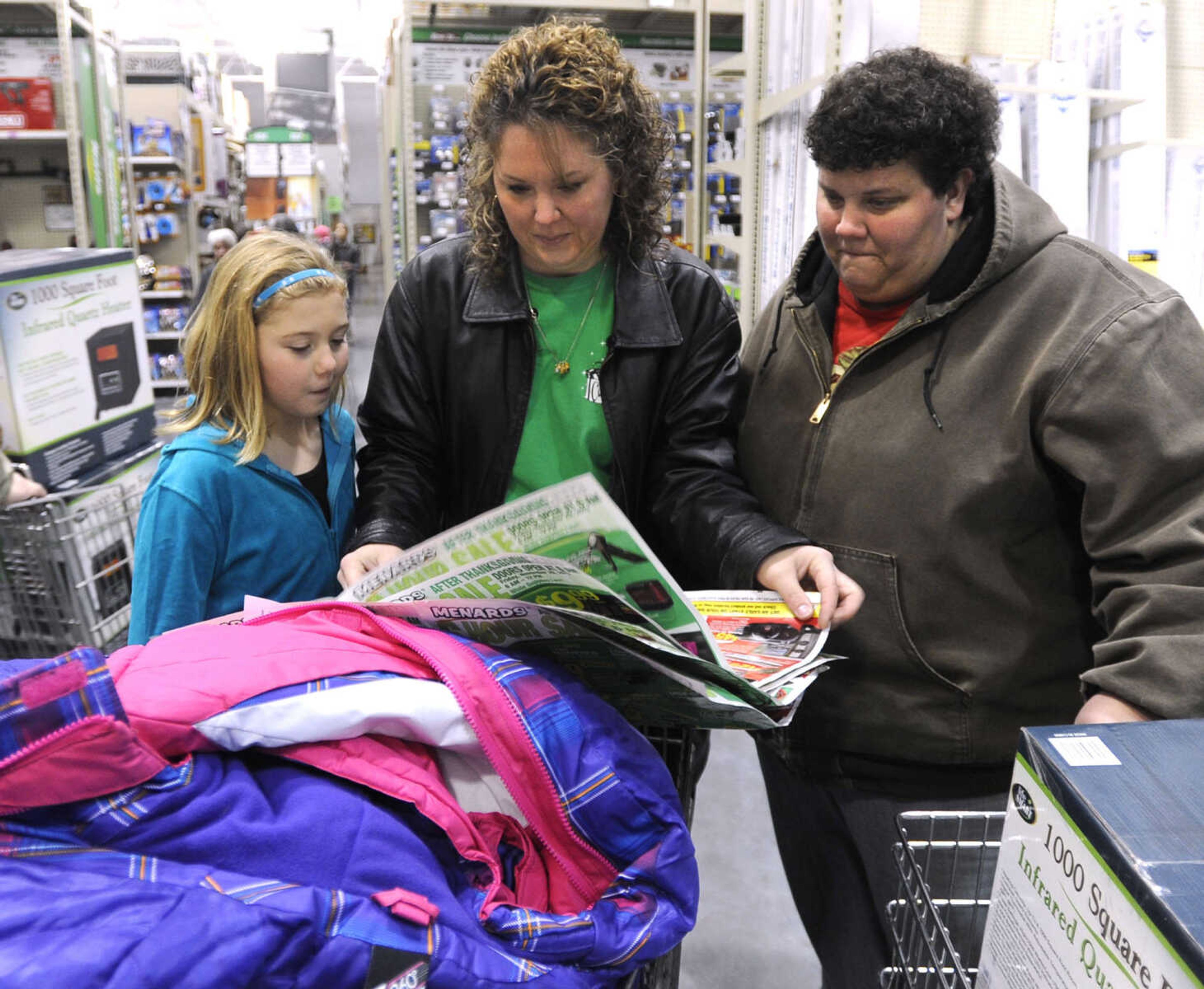 Traci Hency, left, Christy Hency and Jodi Pobst of Oran, Mo. plan their shopping strategy at Menards on Black Friday, Nov. 29, 2013.