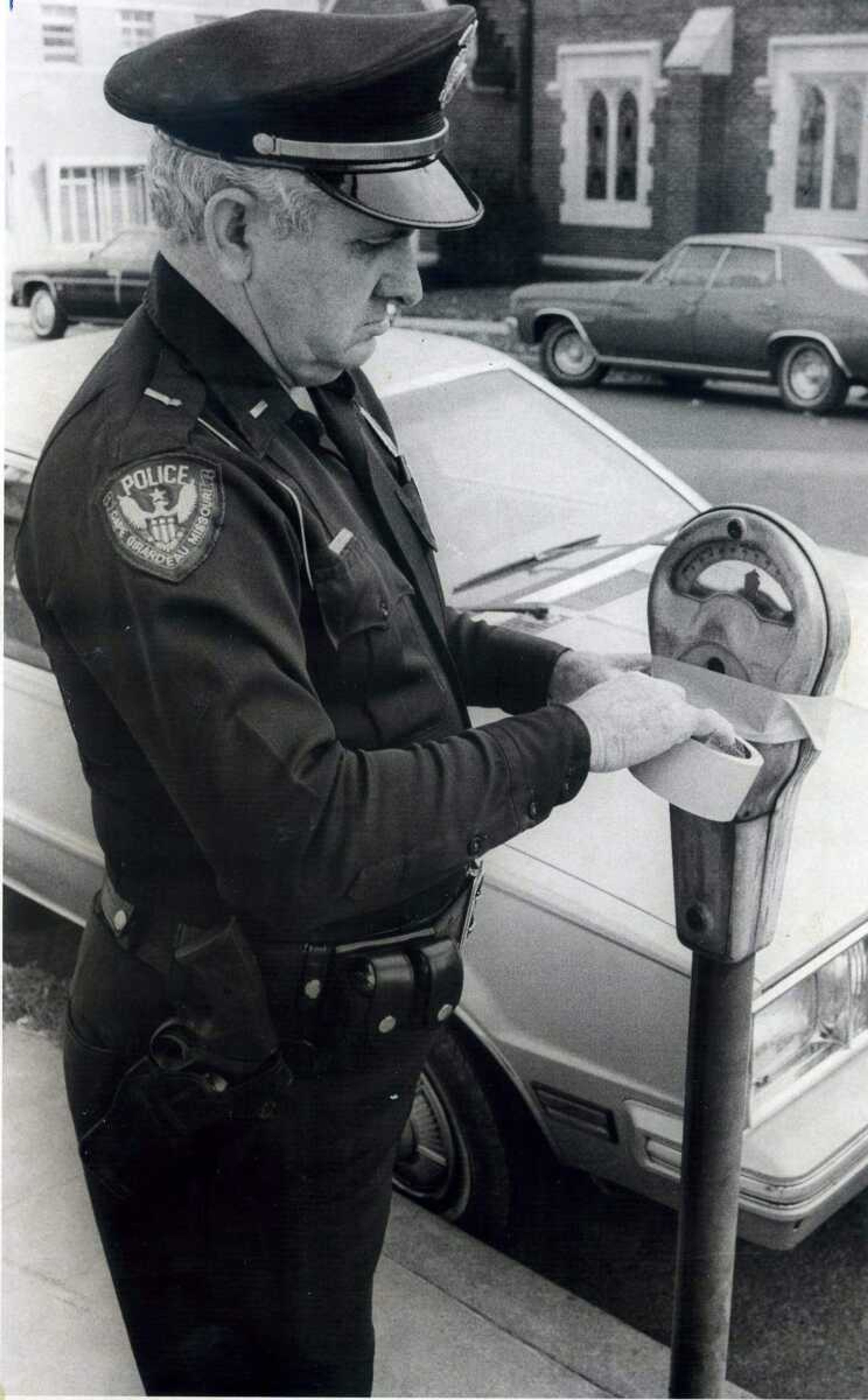 SOUTHEAST MISSOURIAN ~ photos@semissourian.com
Lt. Shannon Kelley tapes parking meter slot after city council orders discontinuance of use of meters