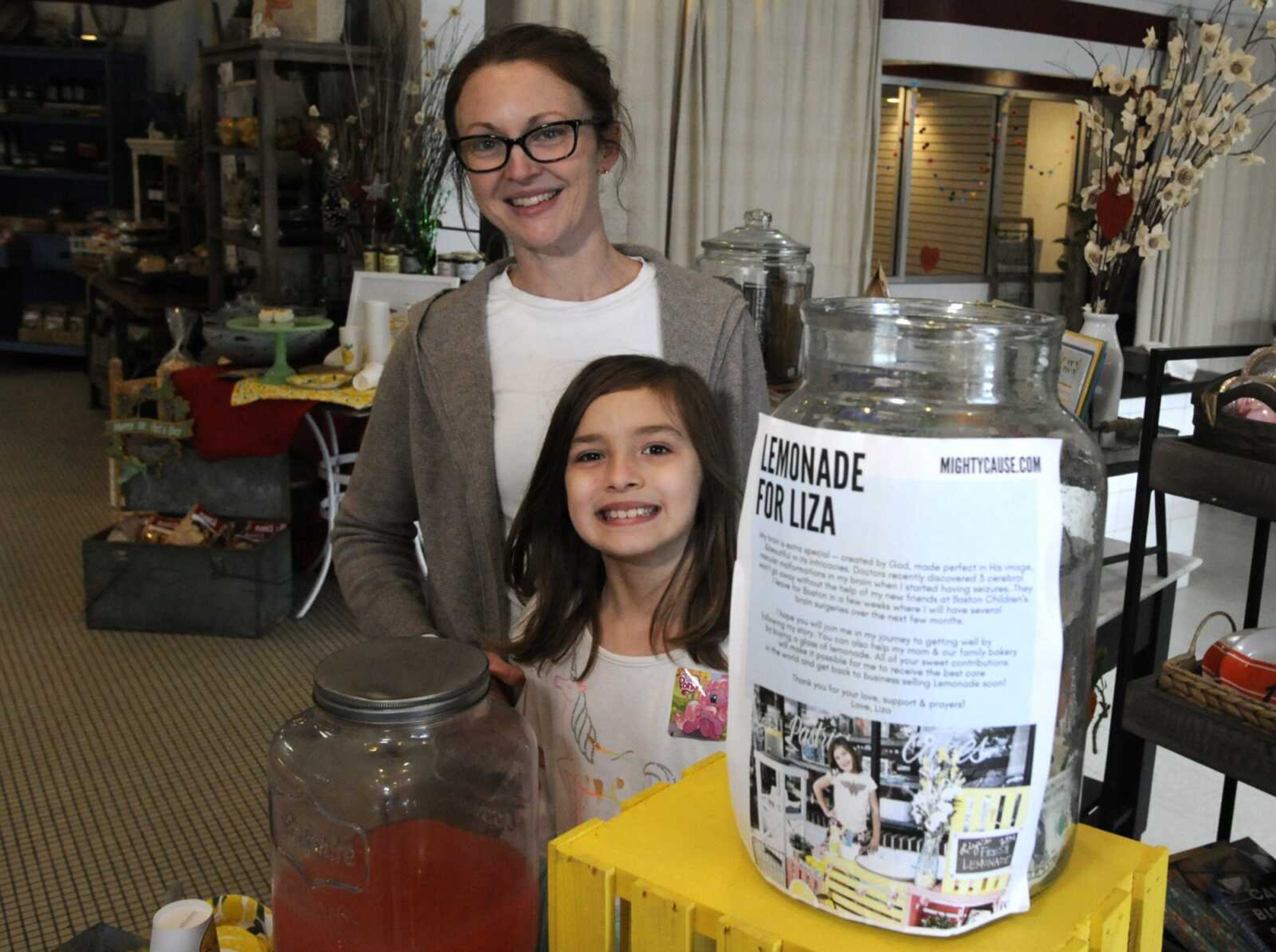 Elizabeth Scott and her 7-year-old daughter, Liza, who is running a lemonade stand to help fund her own brain surgery, are shown at the woman's bakery Tuesday in Homewood, Alabama.