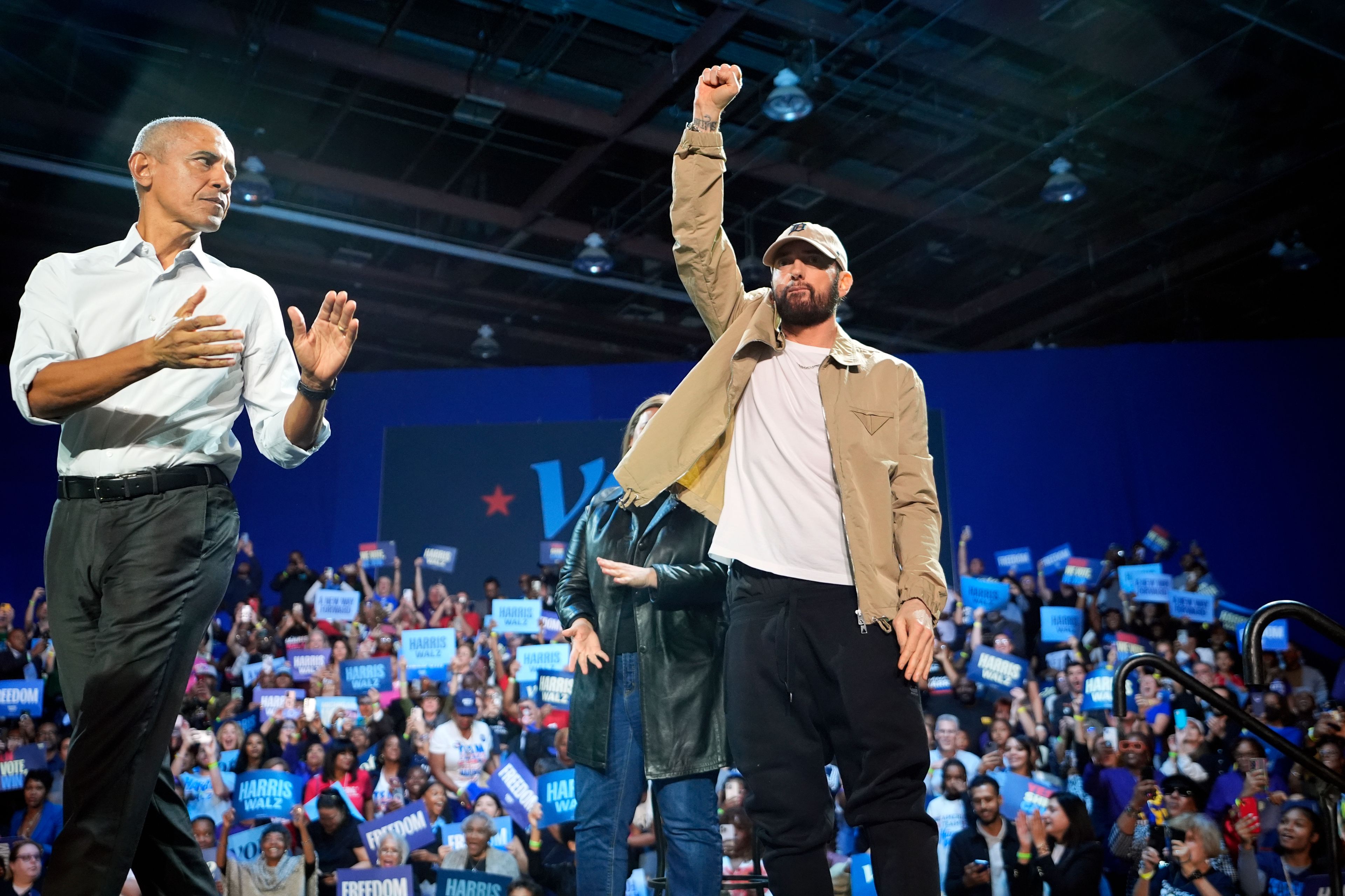 Rapper Eminem, center, greets the crowd on stage with former President Barack Obama, left, at a campaign rally supporting Democratic presidential nominee Vice President Kamala Harris, Tuesday, Oct. 22, 2024, in Detroit. (AP Photo/Paul Sancya)