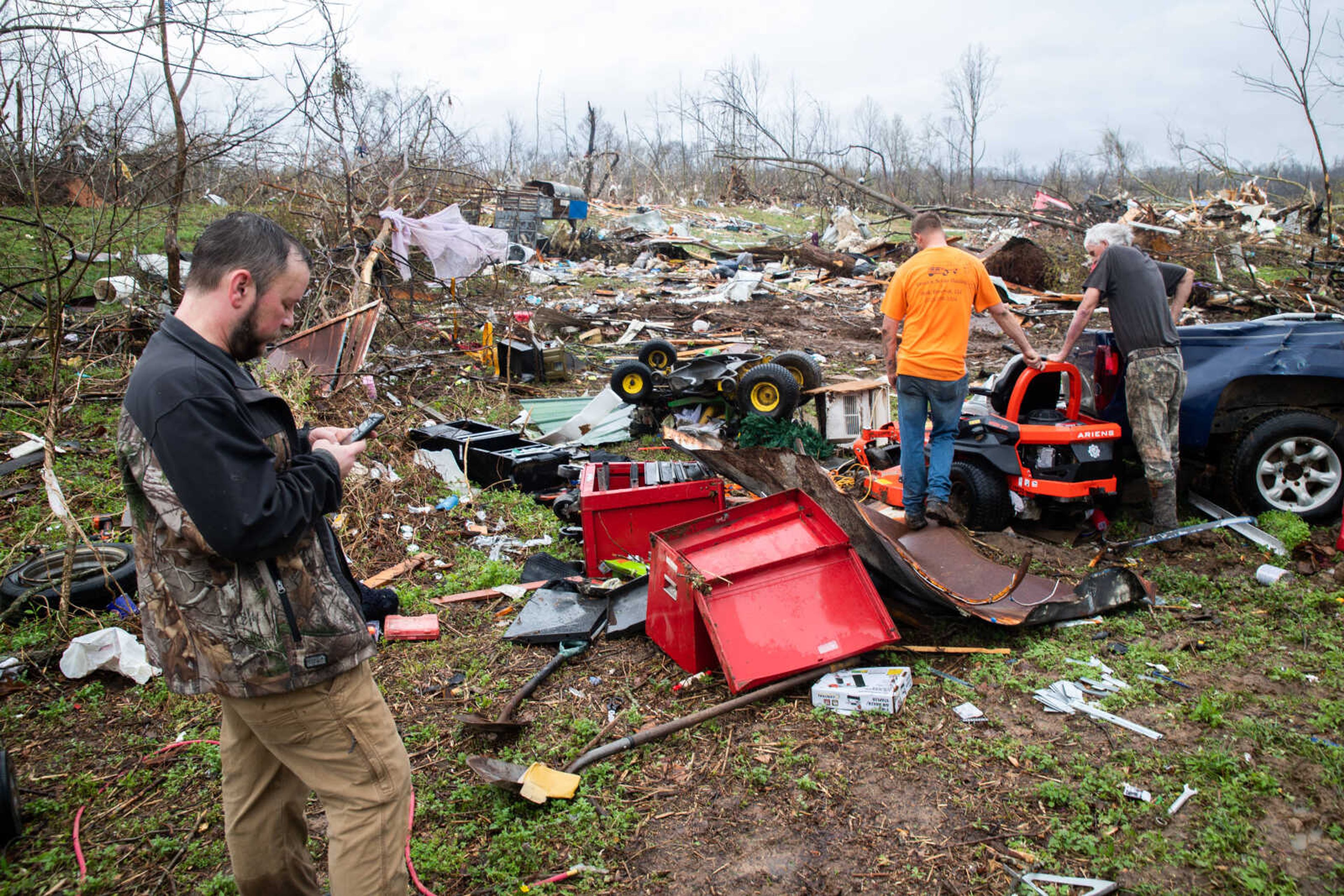 Matt Torbet, left, and Chris and Jerry Green, friends of the family of the deceased, observe the damage left by the tornado on Wednesday, April 5 in Glen Allen.