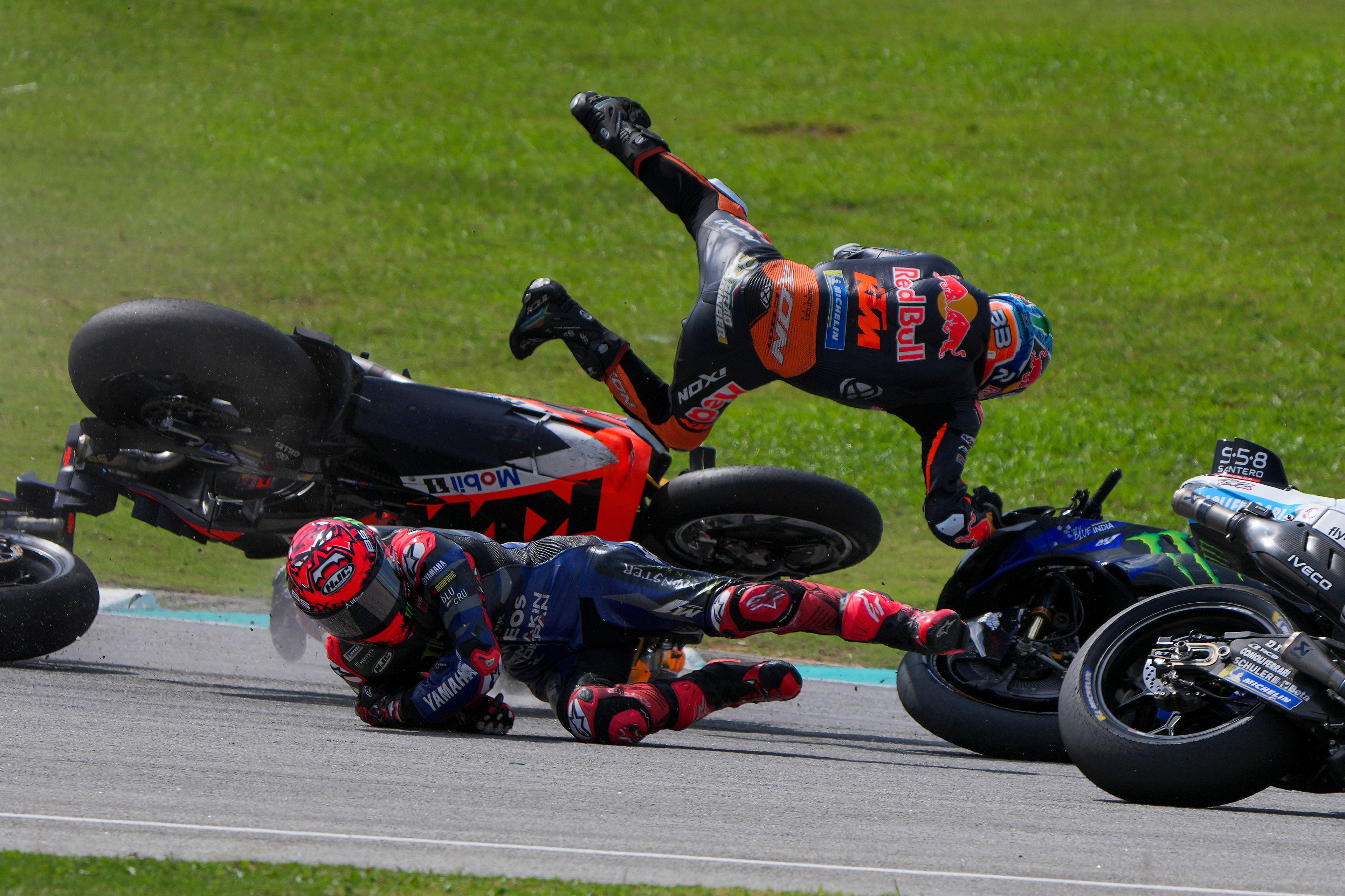 South African rider Brad Binder of Red Bull KTM Factory Racing, top, leaps in the air after crashing with French rider Fabio Quartararo of Monster Energy Yamaha during the start of the MotoGP race in Sepang, outskirts of Kuala Lumpur, Sunday, Nov. 3, 2024. (AP Photo/Vincent Thian)