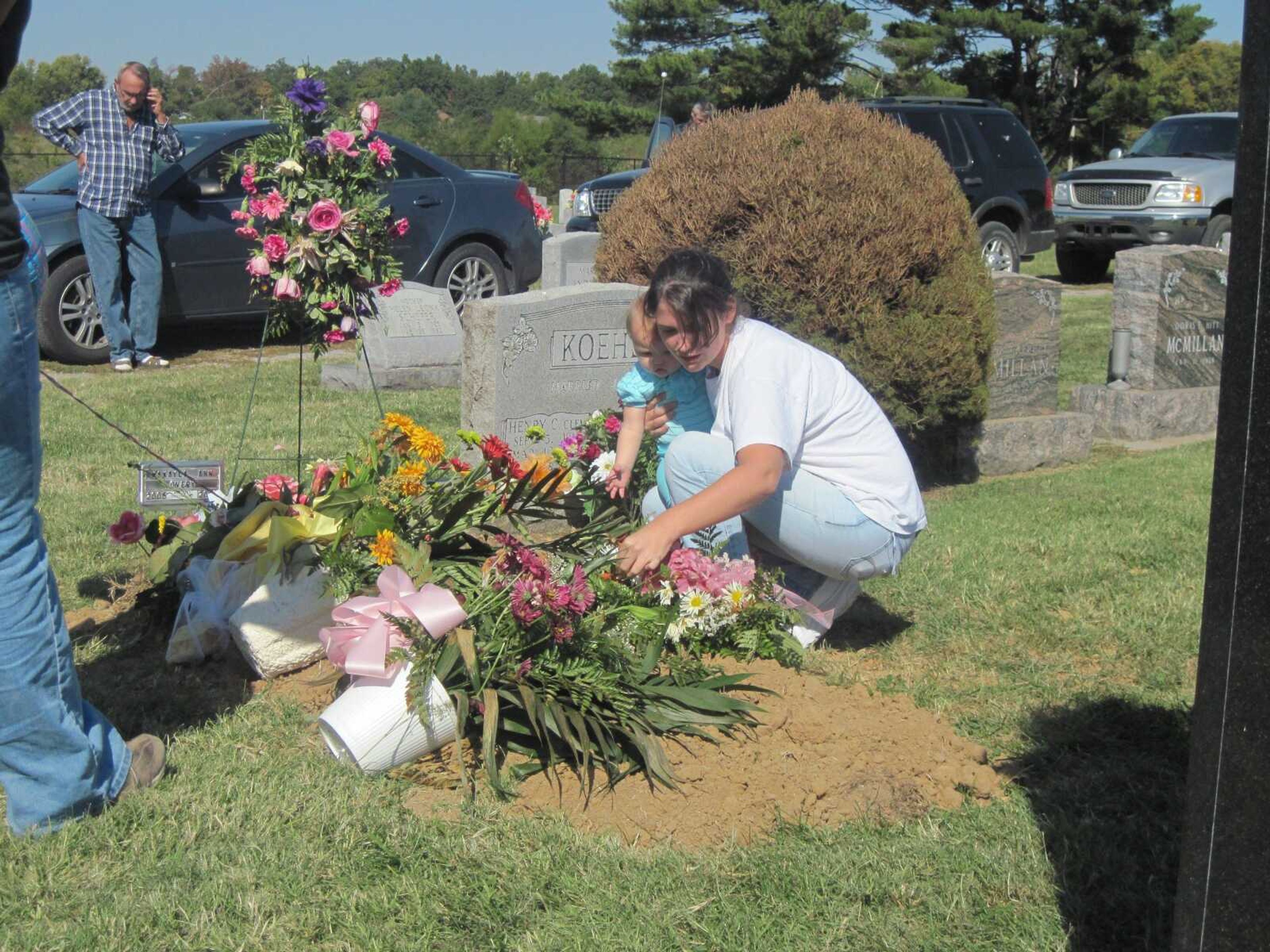 MaKayla Overy's mother Kristen Overy and half-sister Ashton Overy place a flower on MaKayla's grave during a sit-in Thursday, Oct. 7, 2010. MaKayla, who was killed in an accident last week, was buried in the wrong plot. (Carrie Bartholomew)