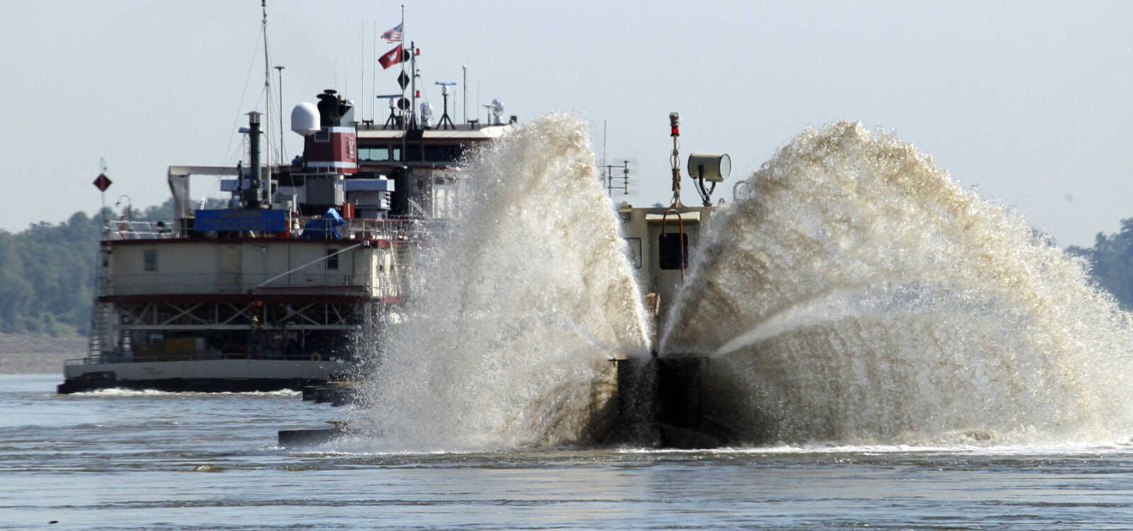 A spray of sand laced water shoots out from the Dredge Jadwin, a U.S. Army Corps of Engineers vessel that is clearing out some of the silt and left over mud and debris from last year's record flood on the Mississippi River and cutting a deeper channel for barges and their towboats to navigate north of Greenville, Miss., Wednesday, Aug. 22, 2012. Coast Guard Capt. William Drelling said Wednesday that authorities would inspect the channel near Greenville, Mississippi, then reset navigation buoys allowing barge traffic to resume on a limited basis as both federal agencies deal with the continued drought that has lowered the Mississippi River. (AP Photo/Rogelio V. Solis)