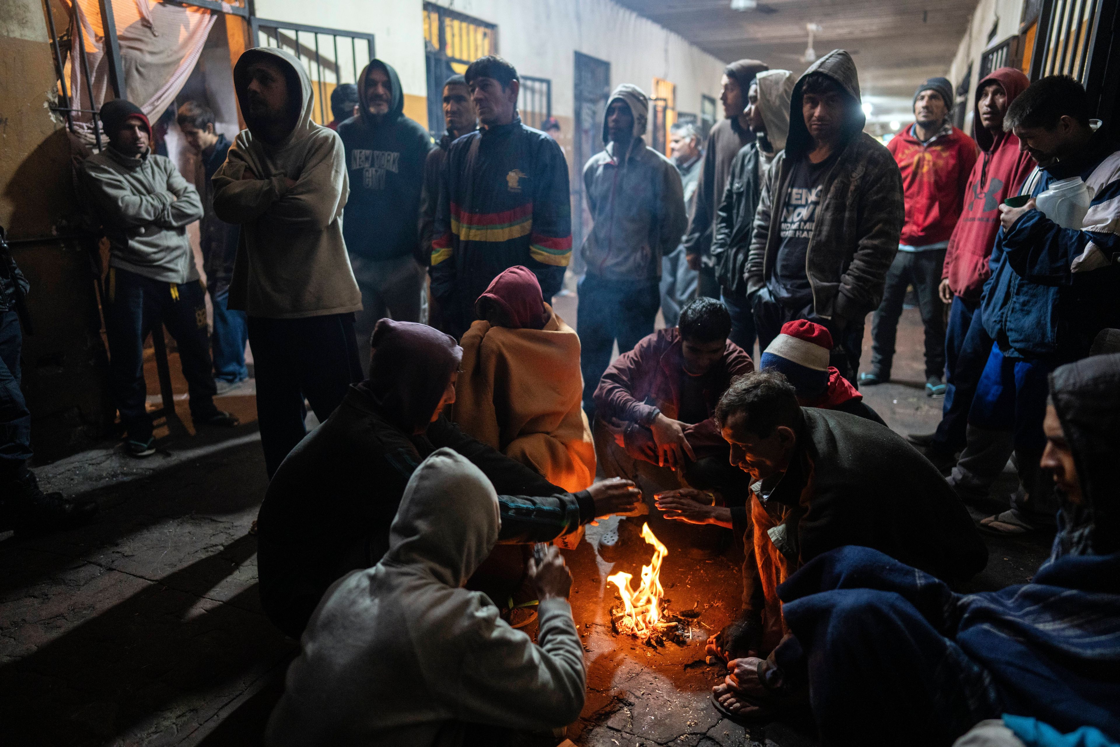 Prisoners warm themselves by a fire inside their pavilion at the Juan de la Vega prison in Emboscada, Paraguay, Friday, July 12, 2024. (AP Photo/Rodrigo Abd)