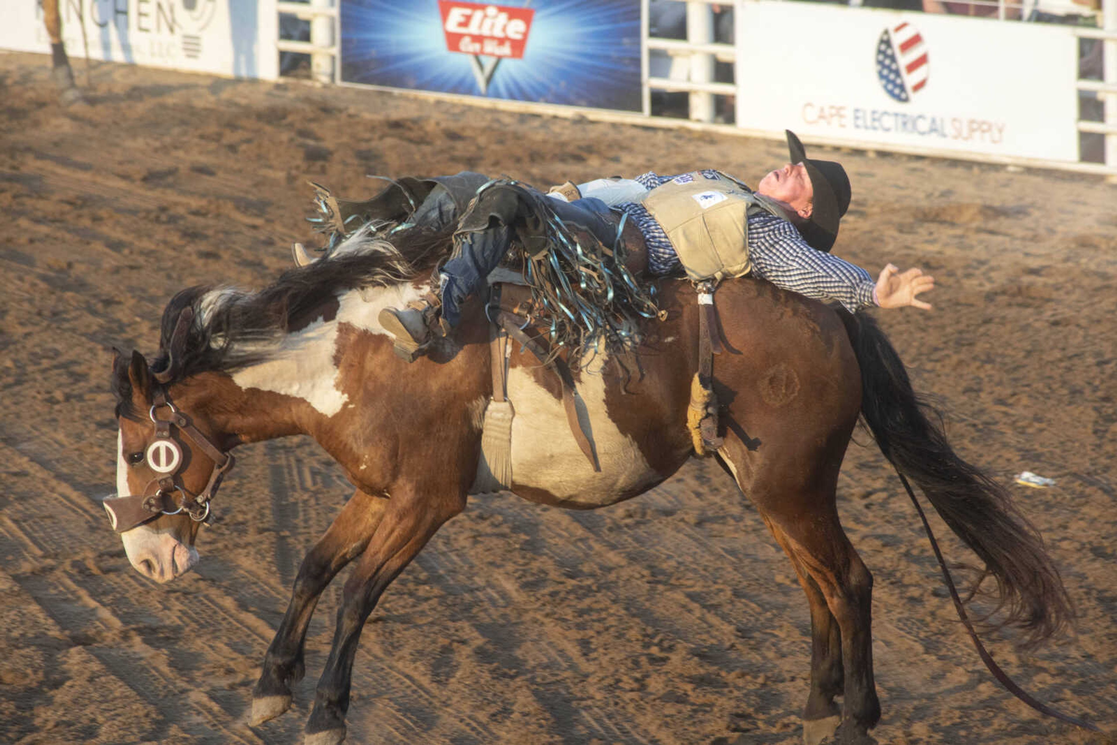 A rider hangs on during the Sikeston Jaycee Bootheel Rodeo on Thursday, Aug. 12, 2021, in Sikeston, Missouri.