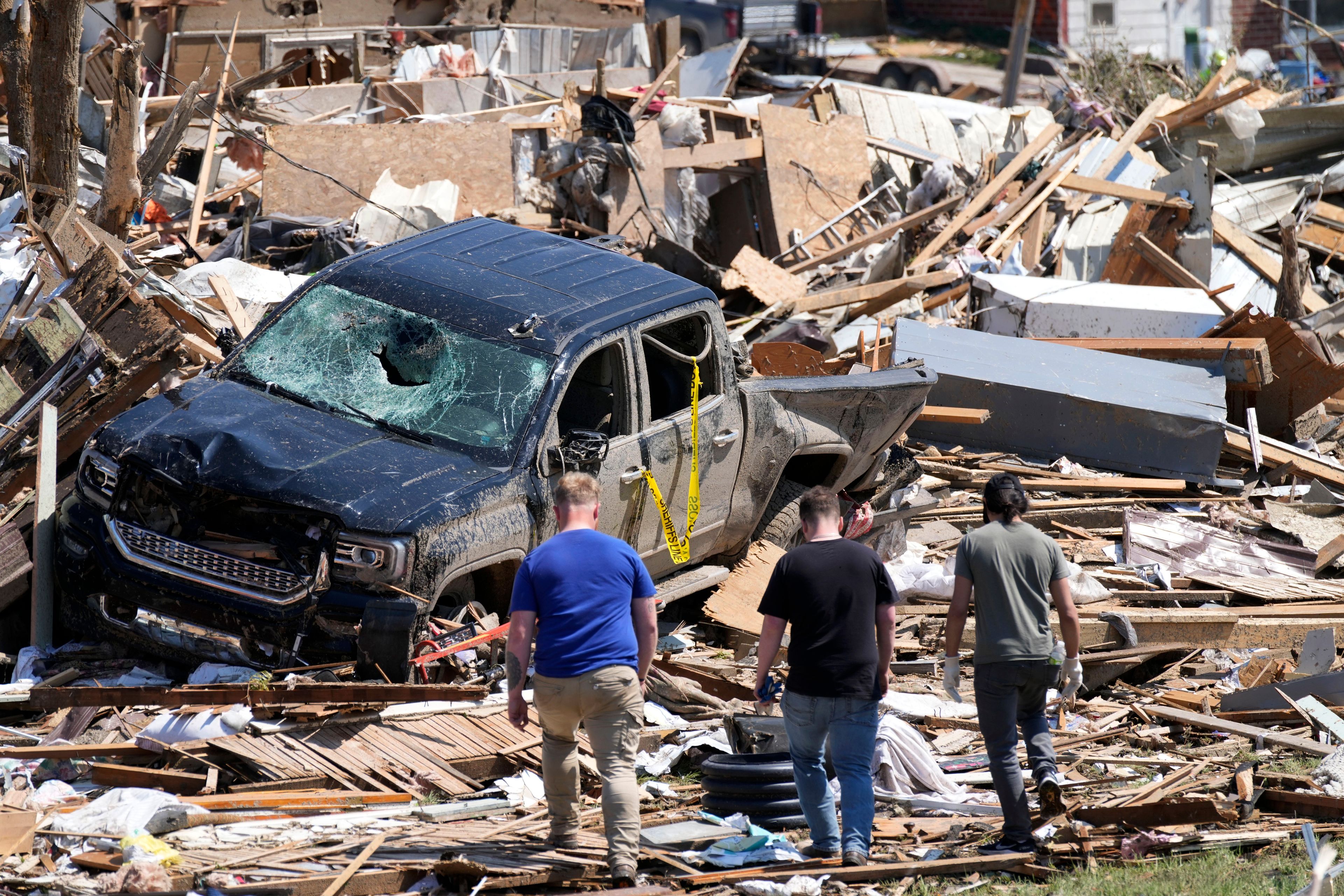 FILE - Local residents walk among the debris from tornado damaged homes, May 22, 2024, in Greenfield, Iowa. (AP Photo/Charlie Neibergall, File)