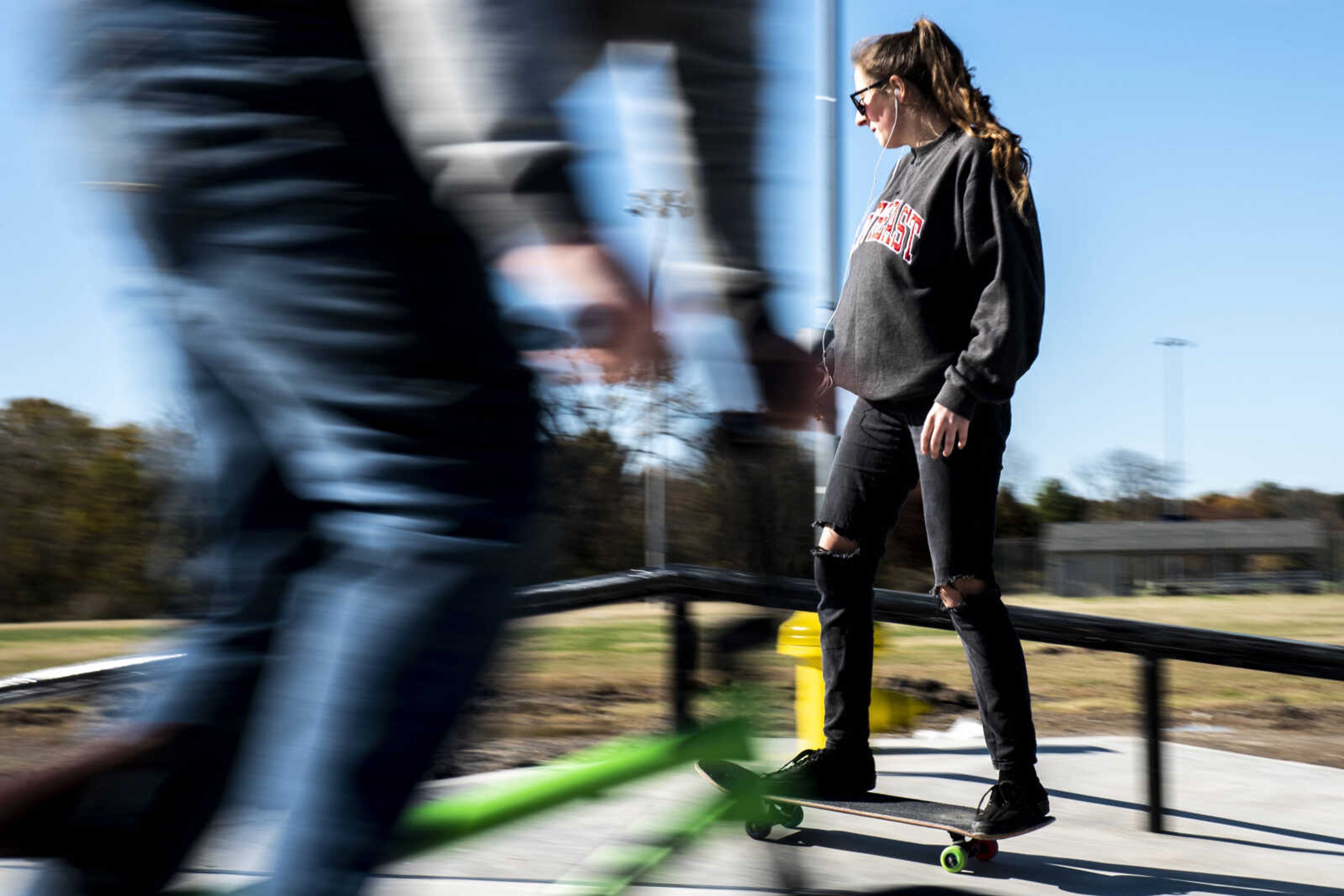 Ashleigh Martin, back, skateboards at the skatepark under construction in Cape Girardeau while Dylan Pavone, front, rides his bike past Wednesday, Nov. 7, 2018.