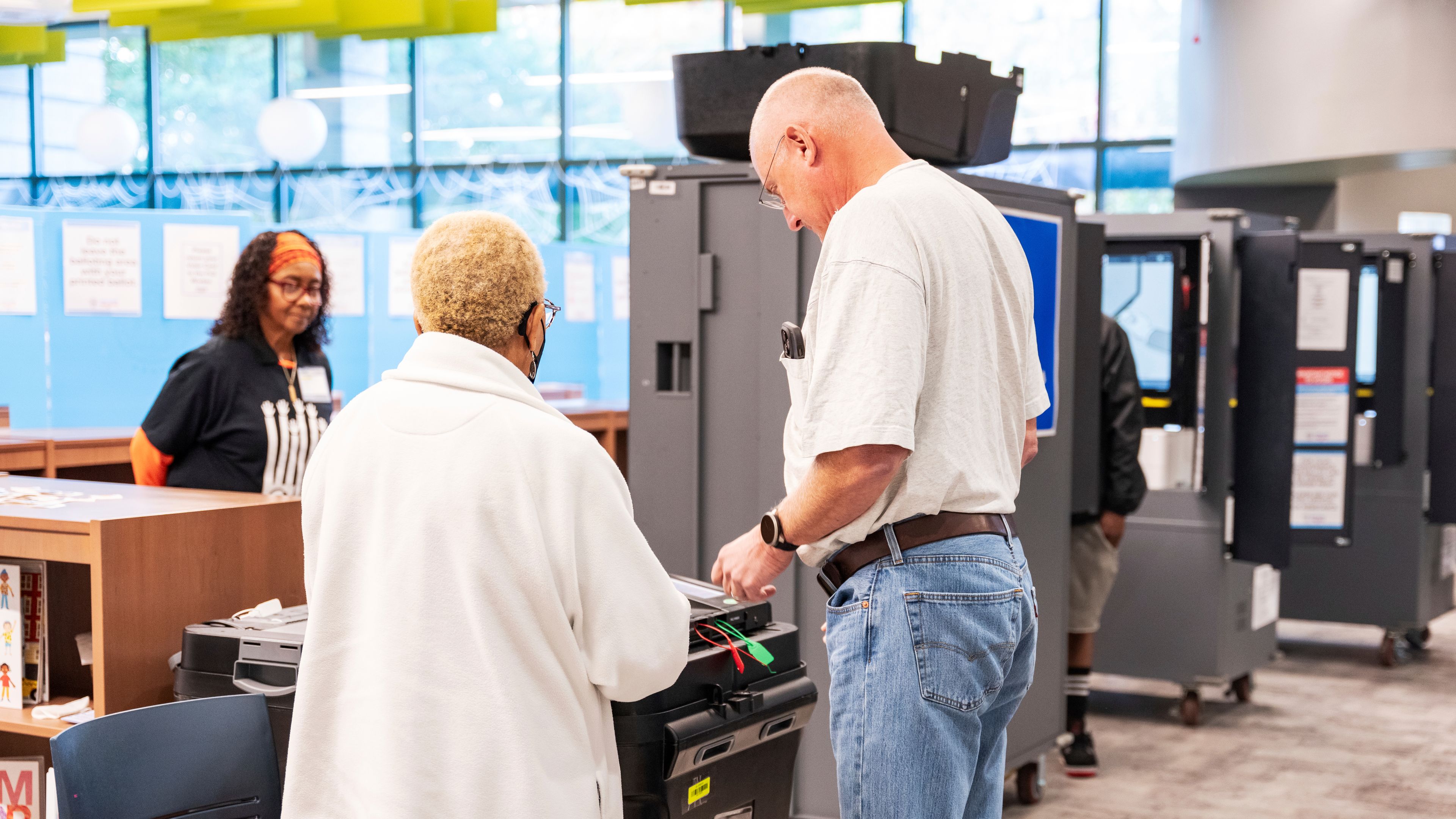 CORRECTS TO CAST BALLOT - A man receives receives instructions from a poll worker on how to properly cast his ballot receipt at the polling station, Thursday, Oct. 31, 2024, in Atlanta. (AP Photo/Jason Allen)