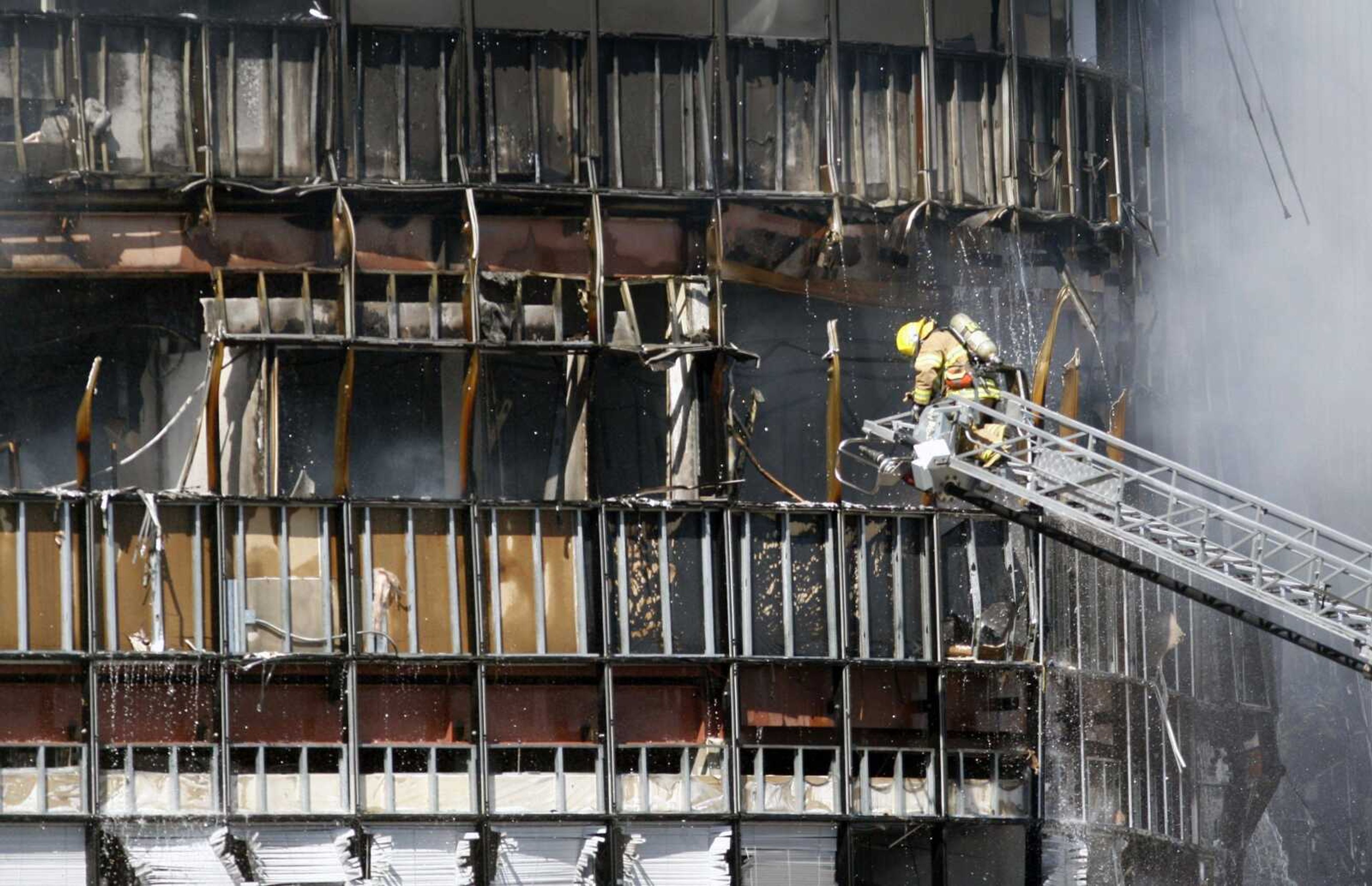 Firefighters work on putting out a fire at a seven-story building after a small private plane crashed into a building that houses the Internal Revenue Service in Austin, Texas on Thursday Feb. 18, 2010. (AP Photo/Jack Plunkett)