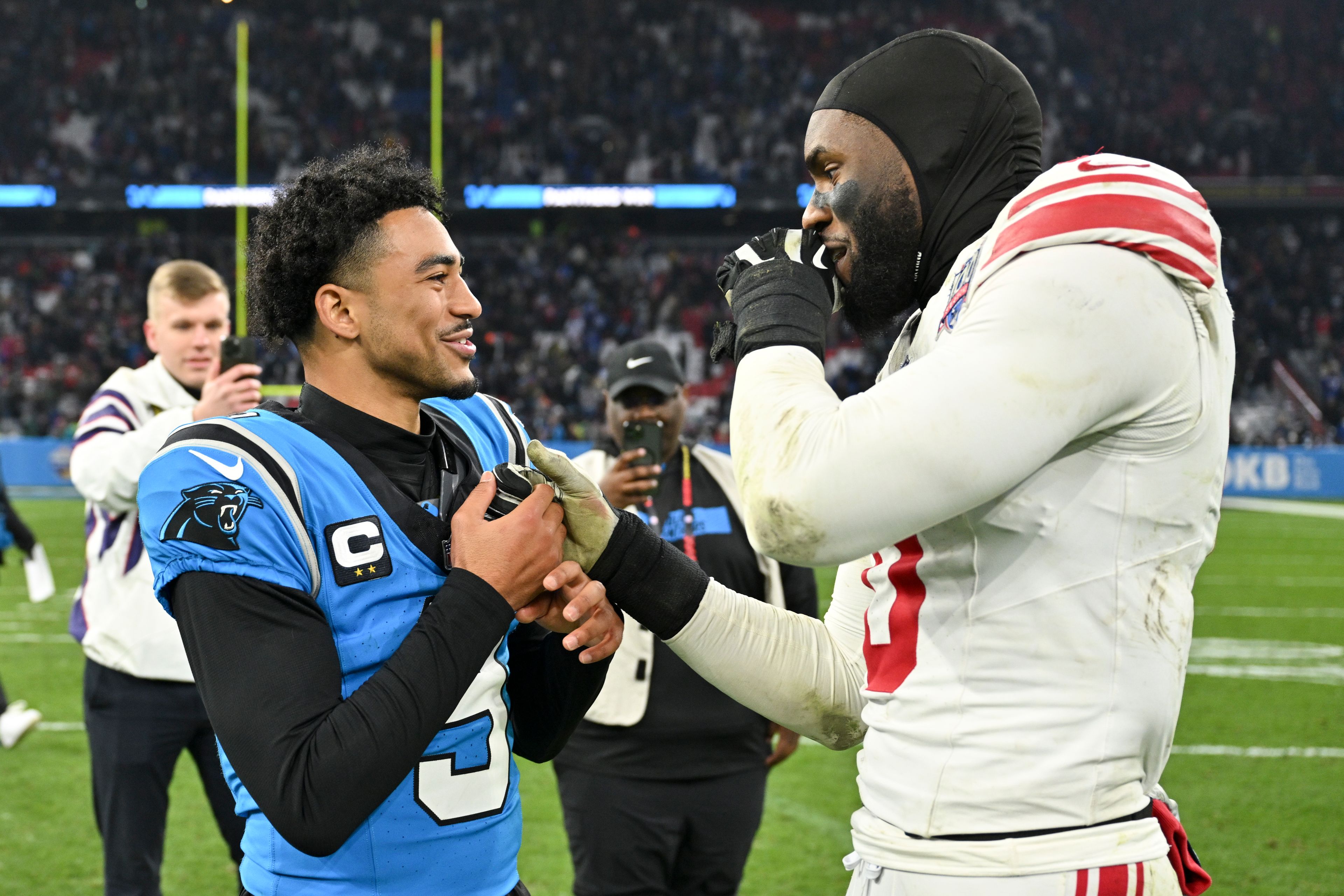 Carolina Panthers quarterback Bryce Young greets New York Giants linebacker Brian Burns after their overtime win in an NFL football game, Sunday, Nov. 10, 2024, in Munich, Germany. (AP Photo/Lennart Preiss)