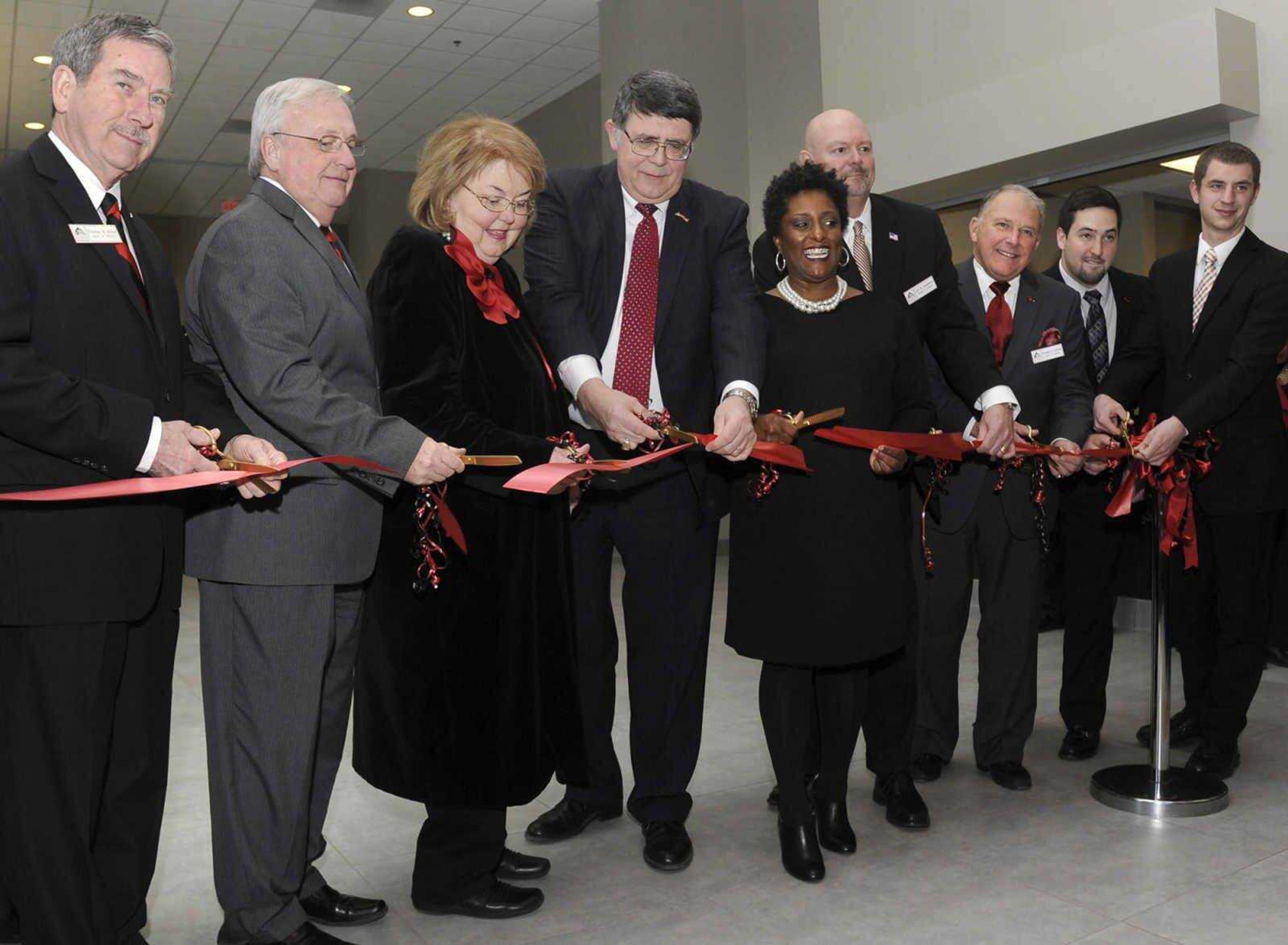 Ken Dobbins and his wife, Jeanine Larson Dobbins, cut a ceremonial ribbon Feb. 27, 2015, after a dedication ceremony for the Kenneth & Jeanine Dobbins River Campus Center. From left are regent Thomas M. Meyer, Board of Regents president Doyle Privett, Jeanine and Ken Dobbins, Board of Regents vice president Kendra Neely-Martin, regent Jay B. Knudtson, regent Donald G. LaFerla, student representative Austin Cordell and Student Government president Caleb Cockrill.