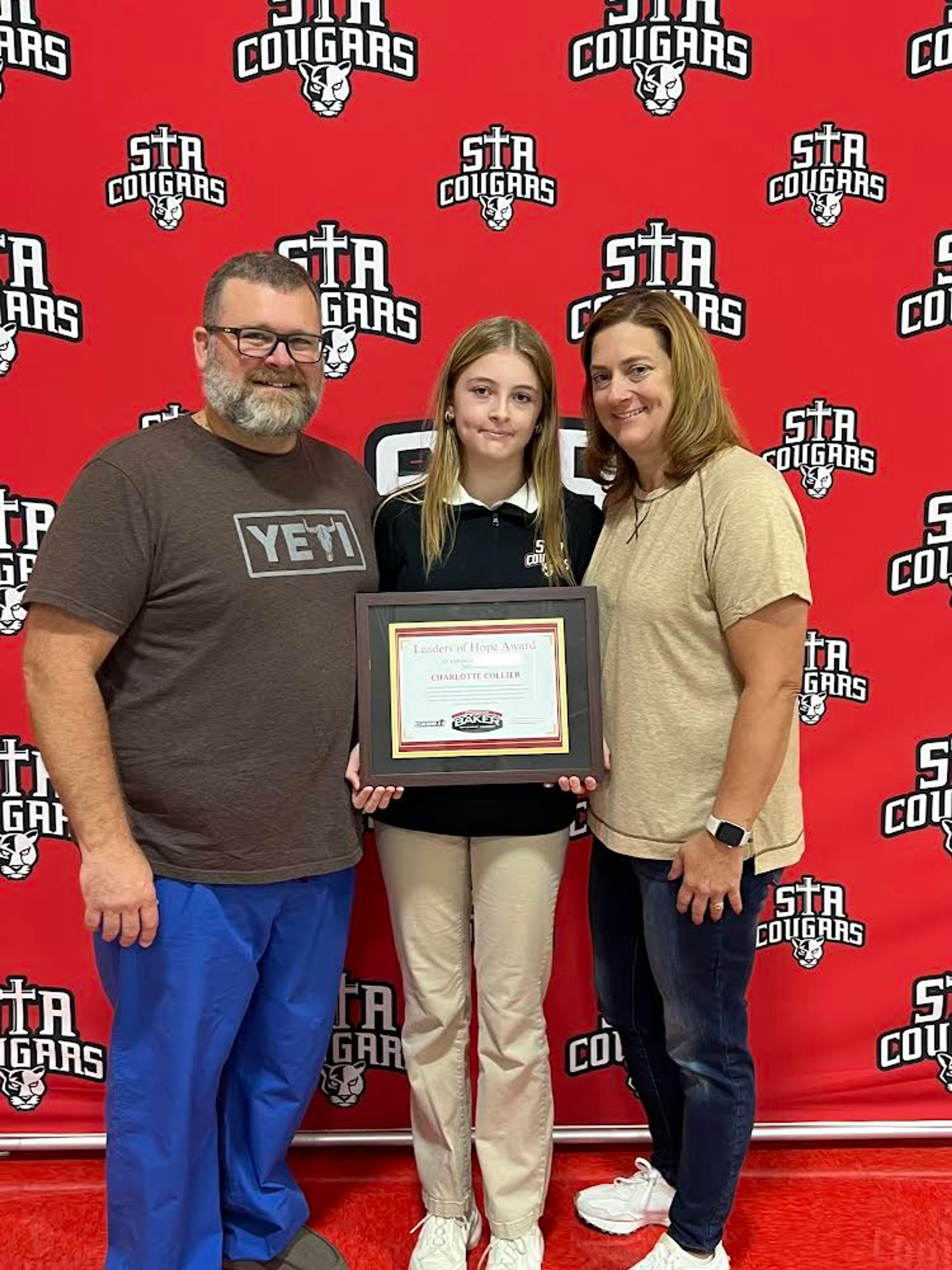 St. Augustine student Charlotte Collier, middle, poses with her parents Allen and Becky Collier after receiving her Leaders of Hope Award.