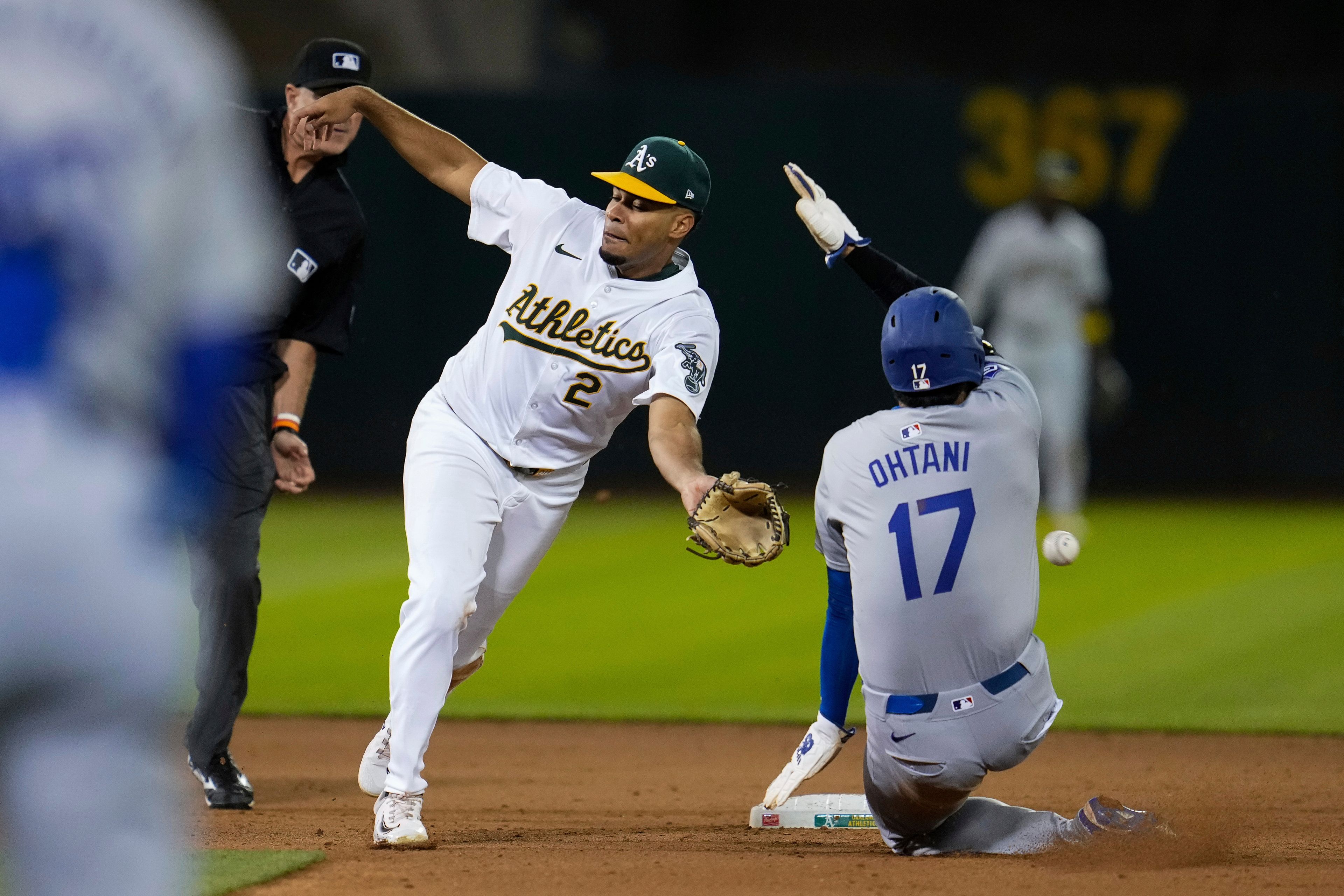 Oakland Athletics second baseman Darell Hernaiz (2) is unable to catch the throw from catcher Shea Langeliers as Los Angeles Dodgers' Shohei Ohtani steals second during the ninth inning of a baseball game, Saturday, Aug. 3, 2024, in Oakland, Calif. (AP Photo/Godofredo A. Vásquez)