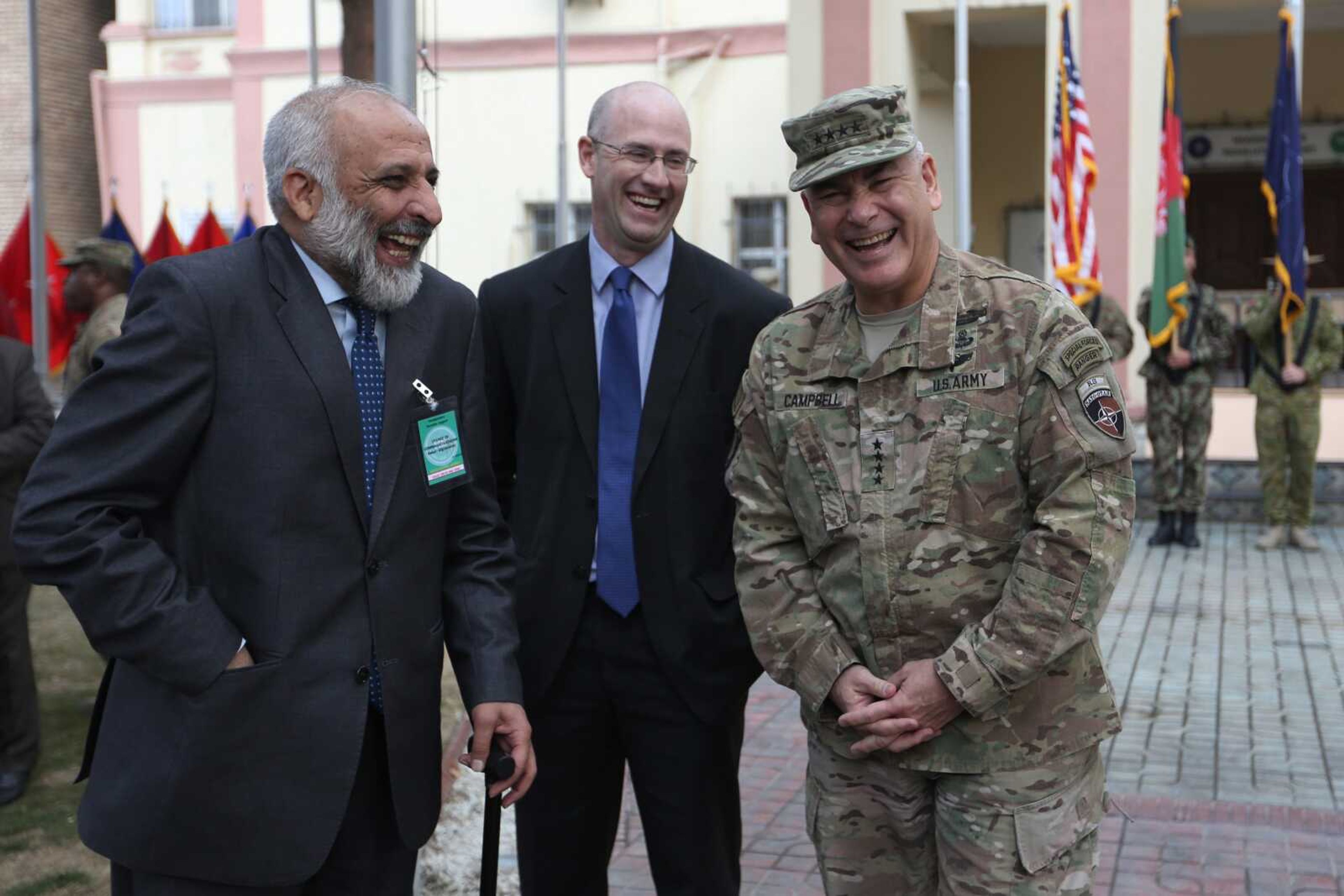 Outgoing Commander of Resolute Support forces and United States forces in Afghanistan, U.S. Army General John Campbell, right, and Afghan head of Afghan government peace negotiating team Mohammad Masoom Stanikzai, left, laugh during a change of command ceremony in Resolute Support headquarters in Kabul, Afghanistan. After months of deliberation Afghan President Ashraf Ghani announced his 21-member team to negotiate peace with the Taliban, only to have his political opponent reject it Friday as not inclusive enough.