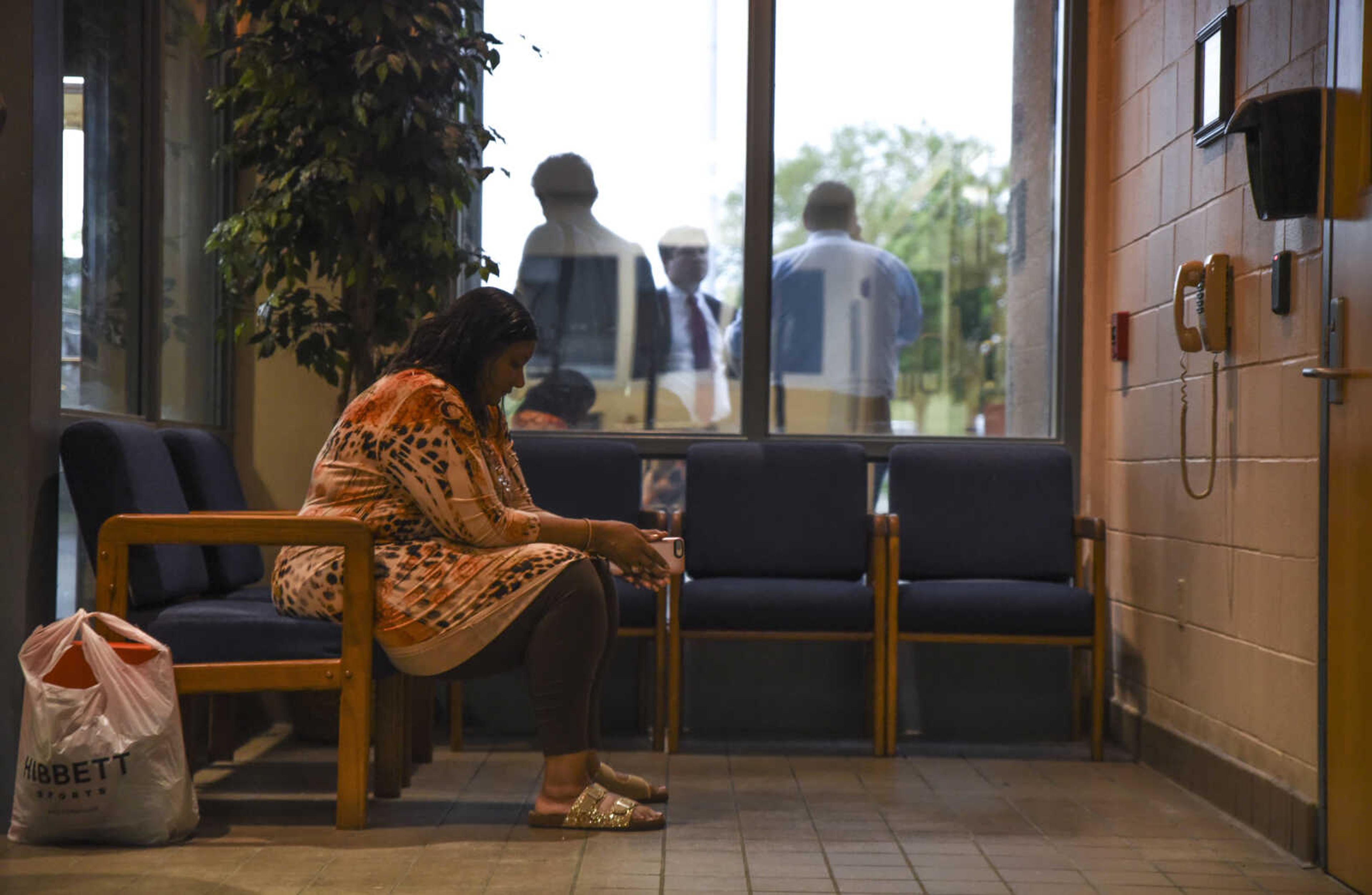 Pat Jackson, David Robinson's wife, sits in the waiting room of the Jefferson City Correctional Center after getting word that David Robinson might not be released on Monday, after all, while David Robinson's attorneys speak amongst themselves outside the window Monday May, 14, 2018 in Jefferson City.