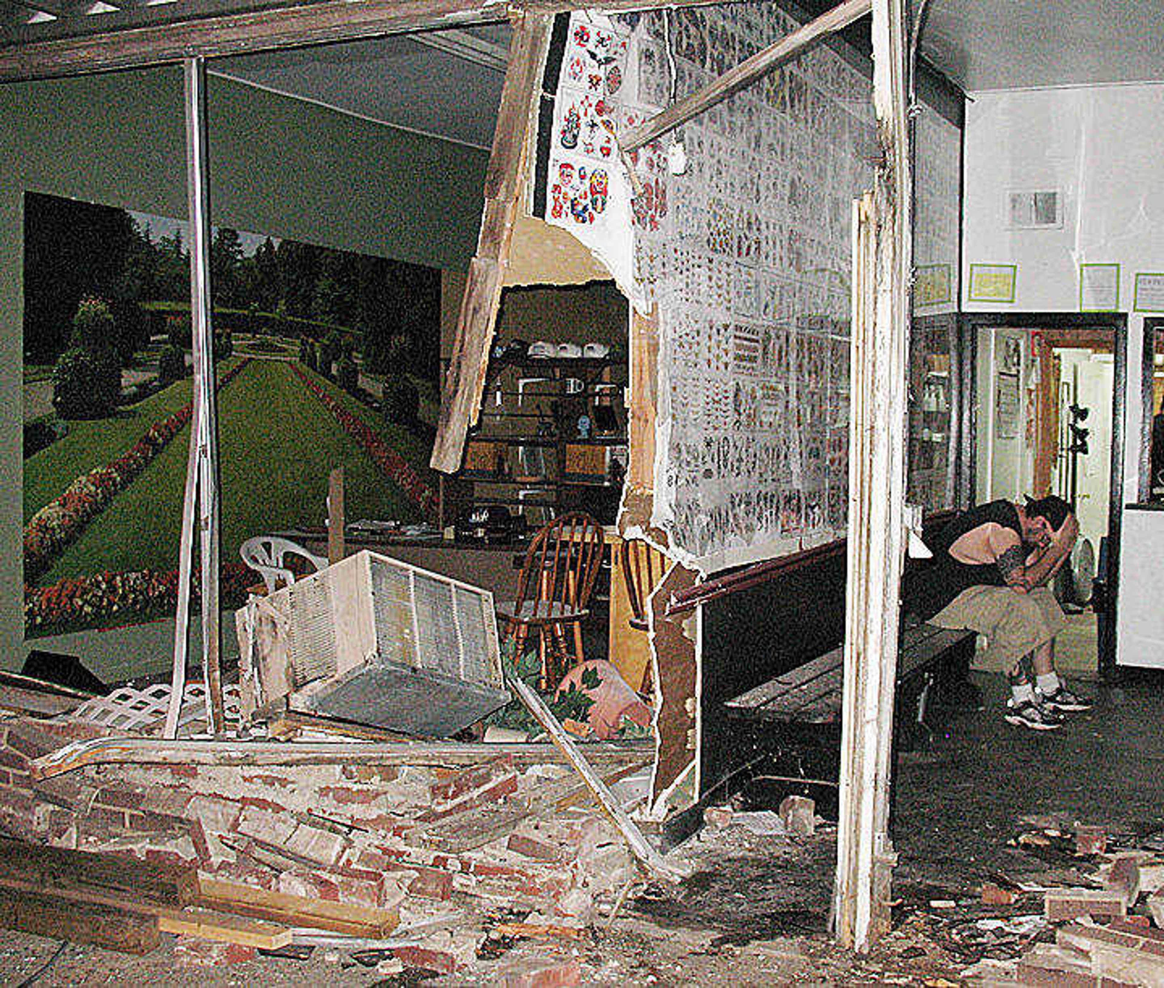 A distraught David Samples, owner of The Ink Emporium, sat in the rubble of his tattoo parlor with his head in his hands after an automobile crashed into the building on Saturday evening. (George Anderson/Daily Dunklin Democrat)