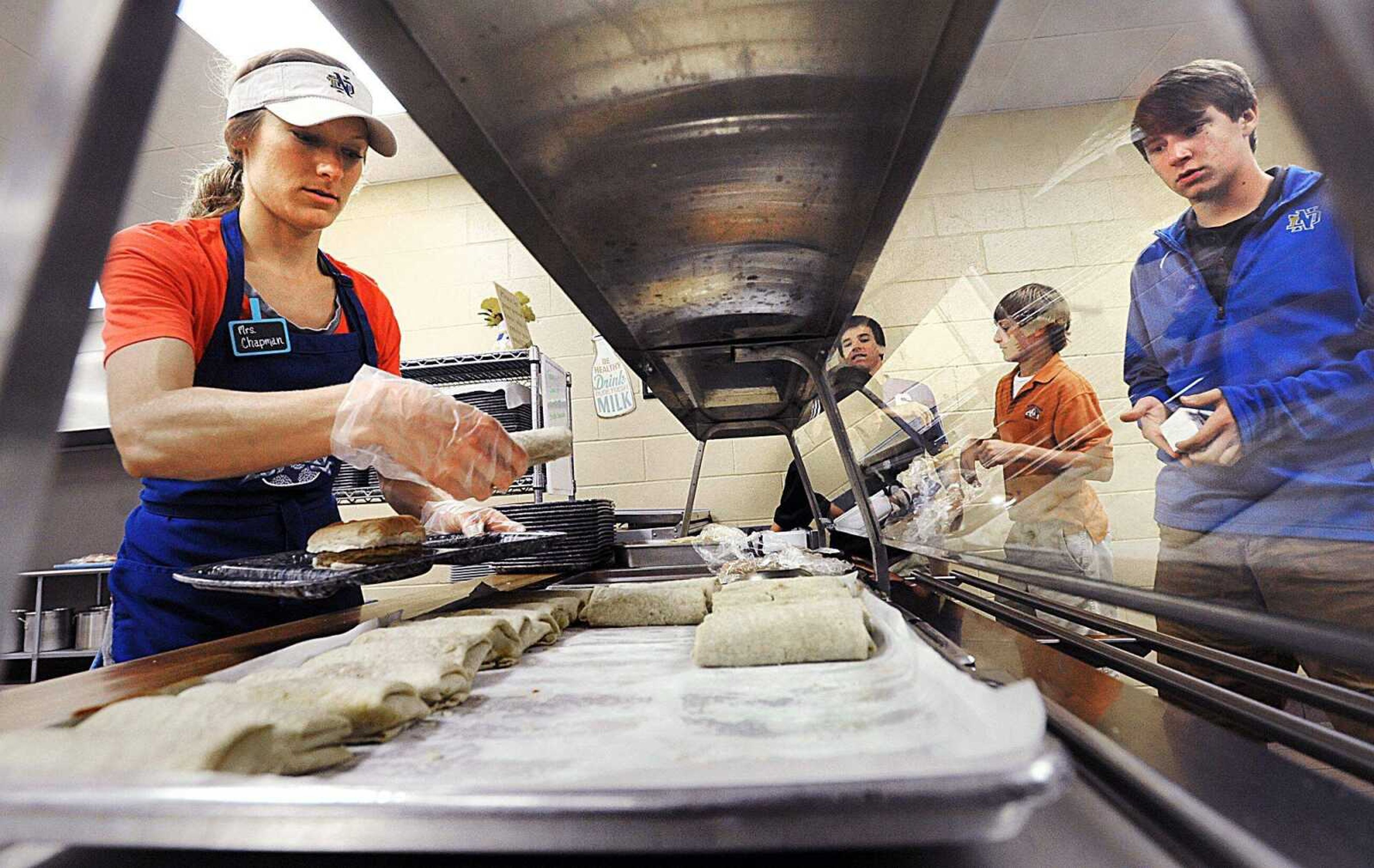 Alyssa Chapman plates a burrito for Cy Young as he makes his way through the lunch line Sept. 4 at Notre Dame Regional High School. (Laura Simon)